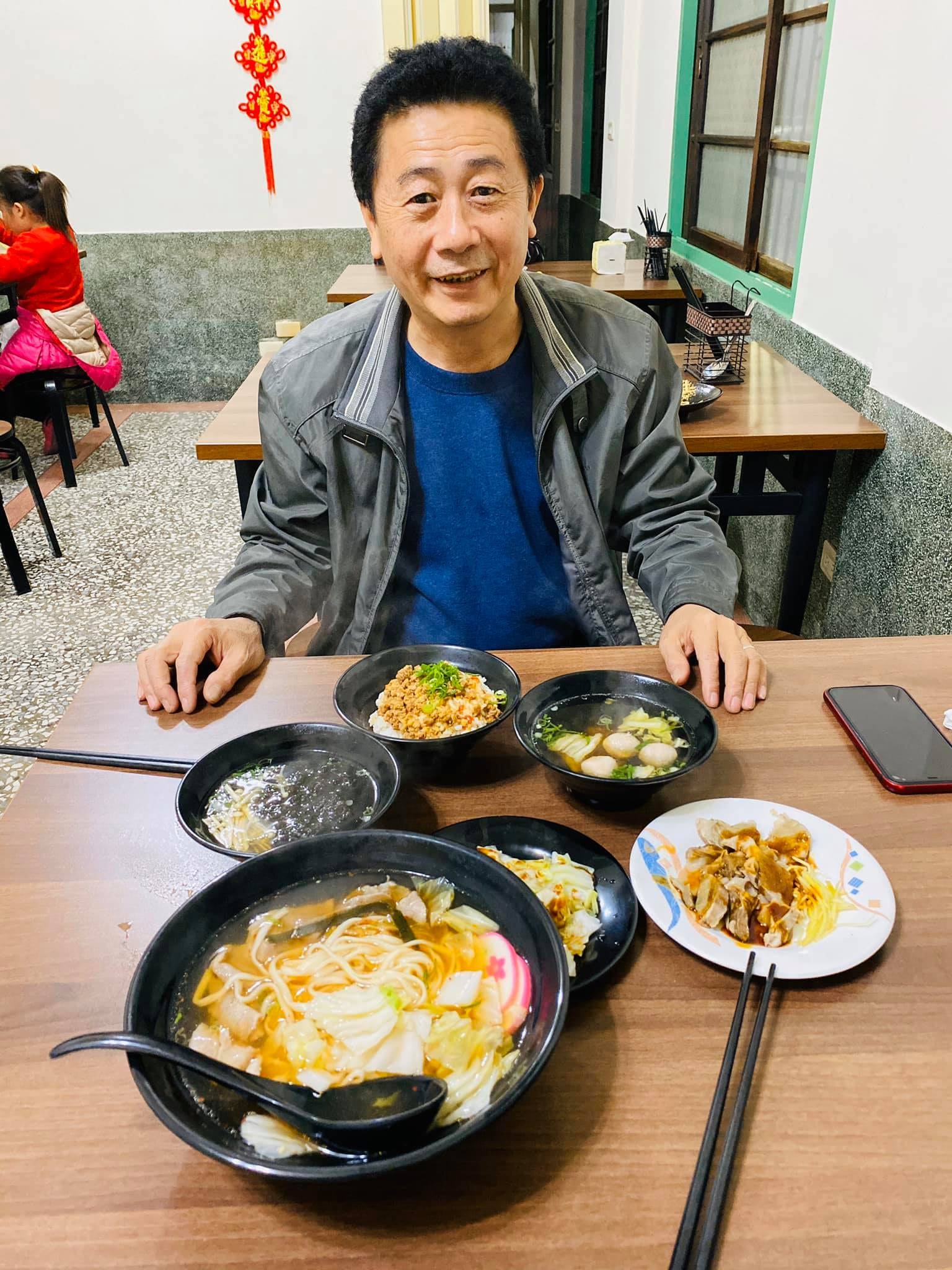 柯爸在台南的小吃店裡，面前擺著湯麵和小菜