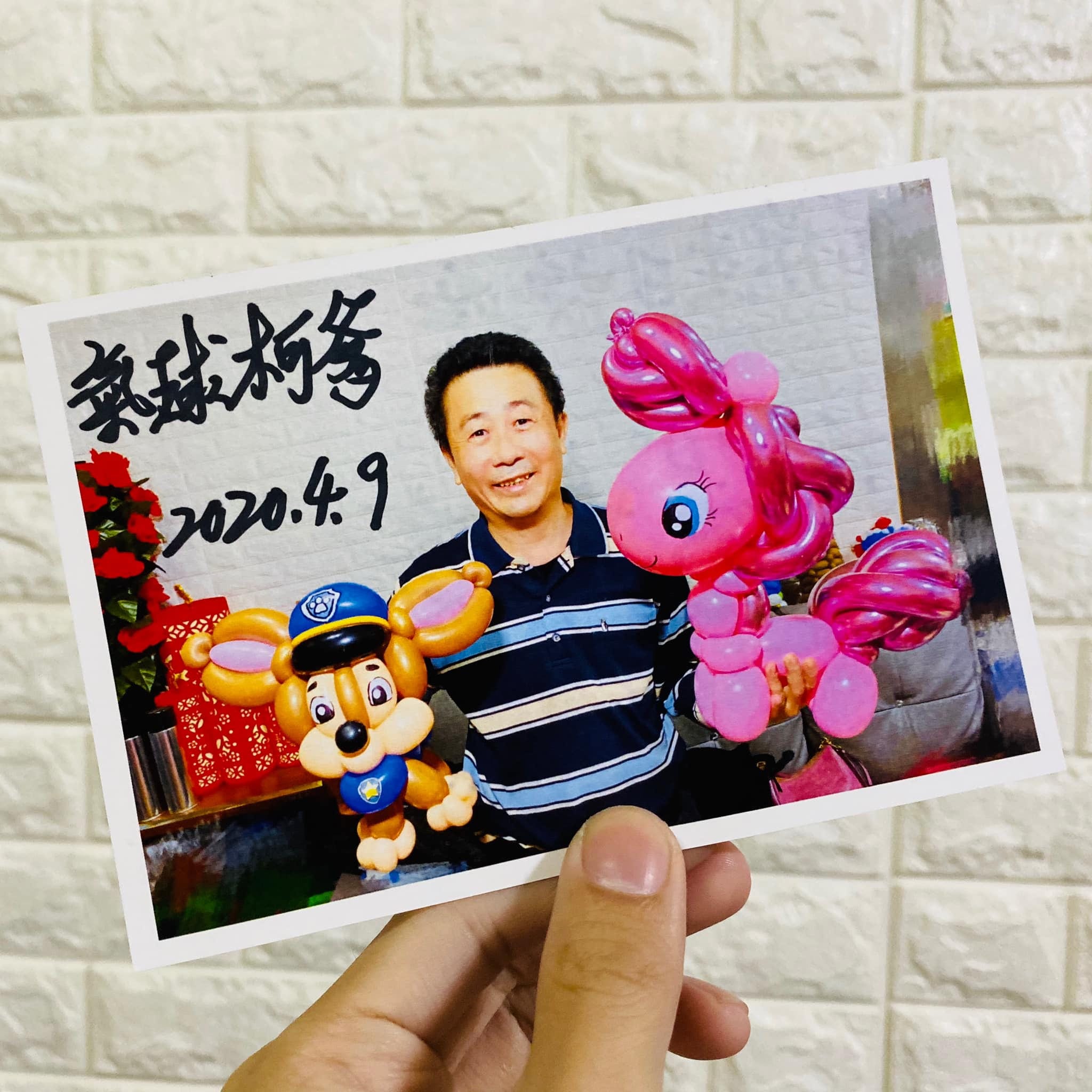 氣球柯爹簽名照,照片中柯爹拿著阿奇與粉紅小馬氣球