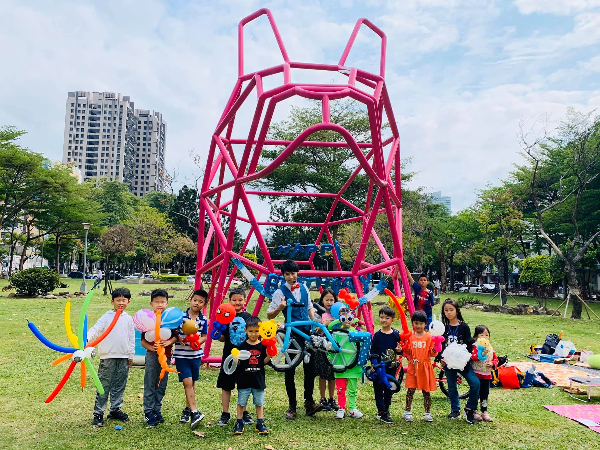 台中戶外生日派對,小朋友和大型腳踏車造型氣球在草地合照