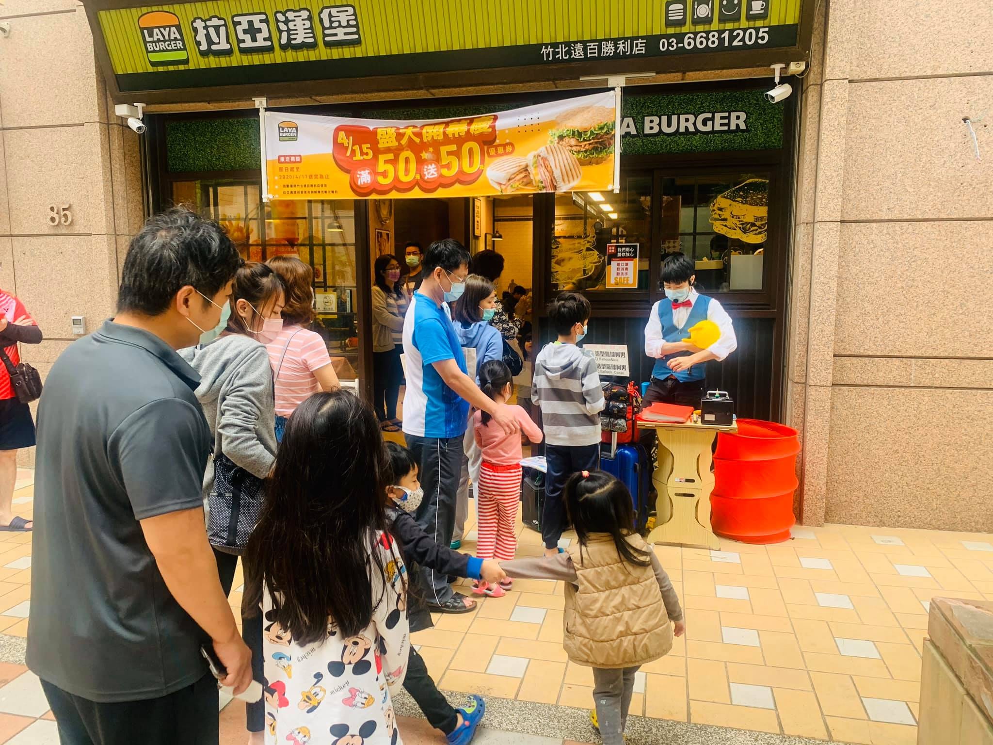 新竹竹北拉亞漢堡門市前，戴口罩的親子排隊等折氣球