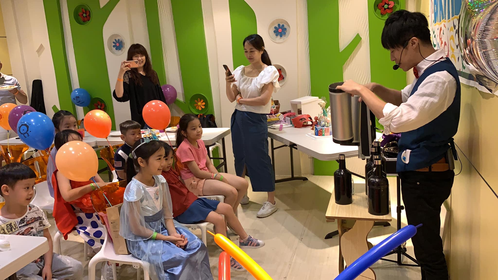 我戴著耳麥表演魔術，小朋友坐在椅子上專心看