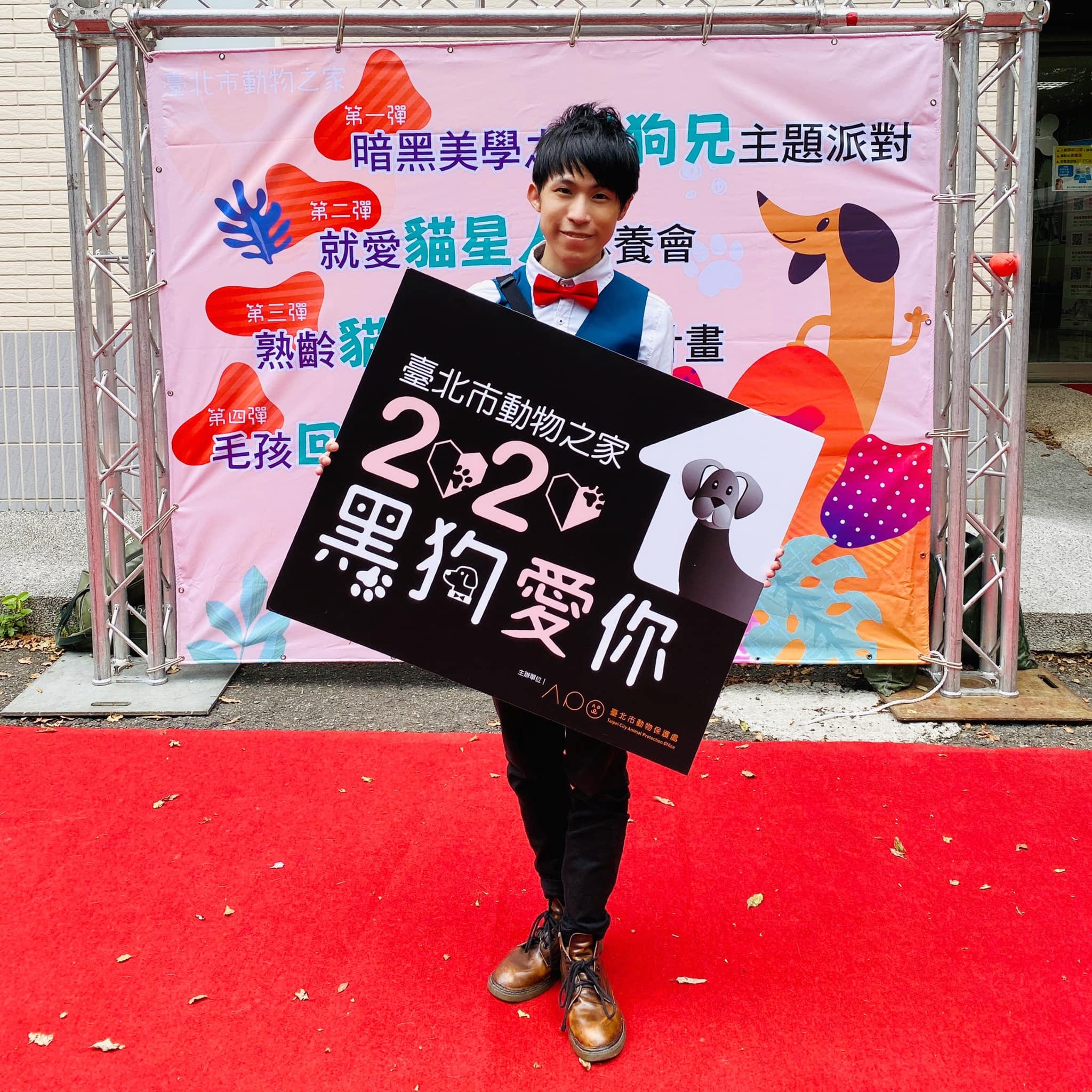 我在紅地毯上舉著 2020 黑狗愛你活動手舉牌