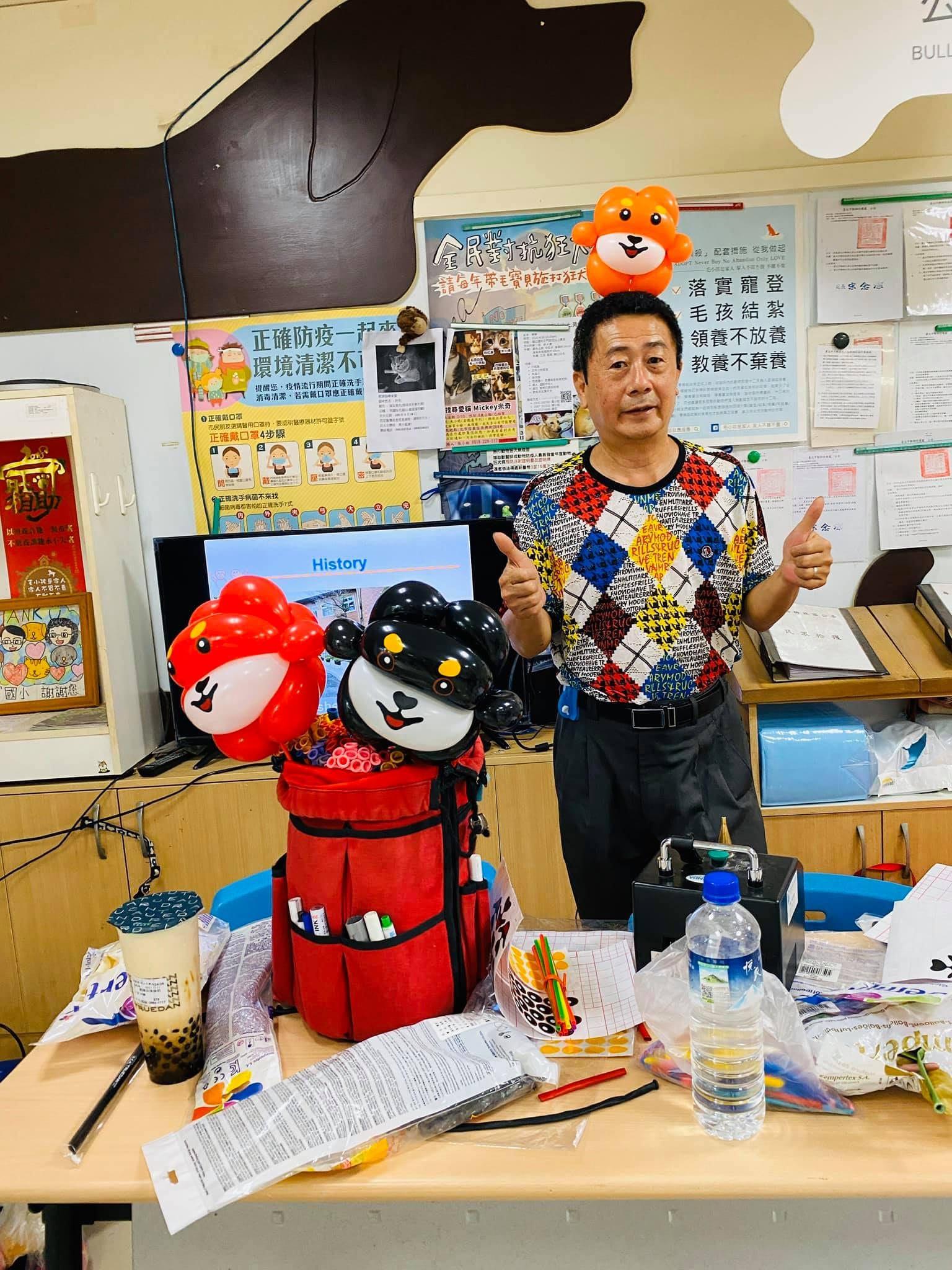 工作桌上紅色與黑色狗頭造型氣球擺飾和氣球工具