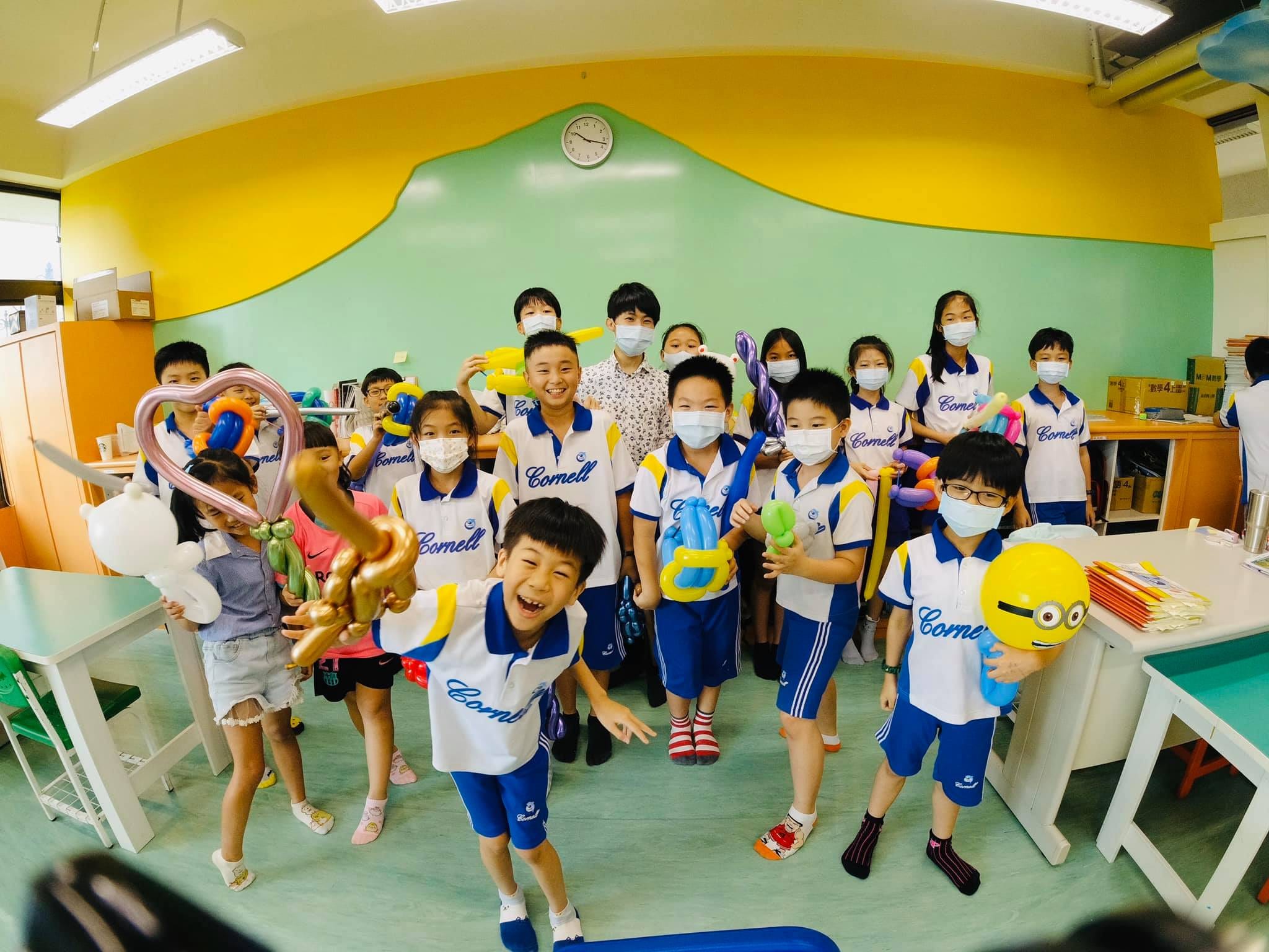 穿白藍制服的小學生拿著金色寶劍與小小兵氣球歡呼