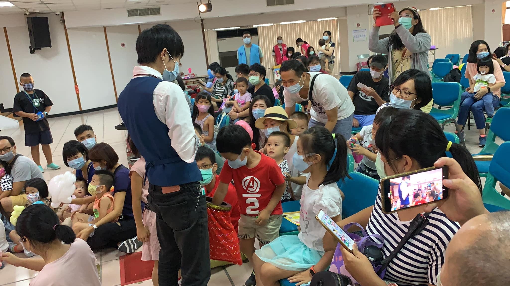 魔術師走到台下，請紅衣小男孩把手伸進紅色魔術袋