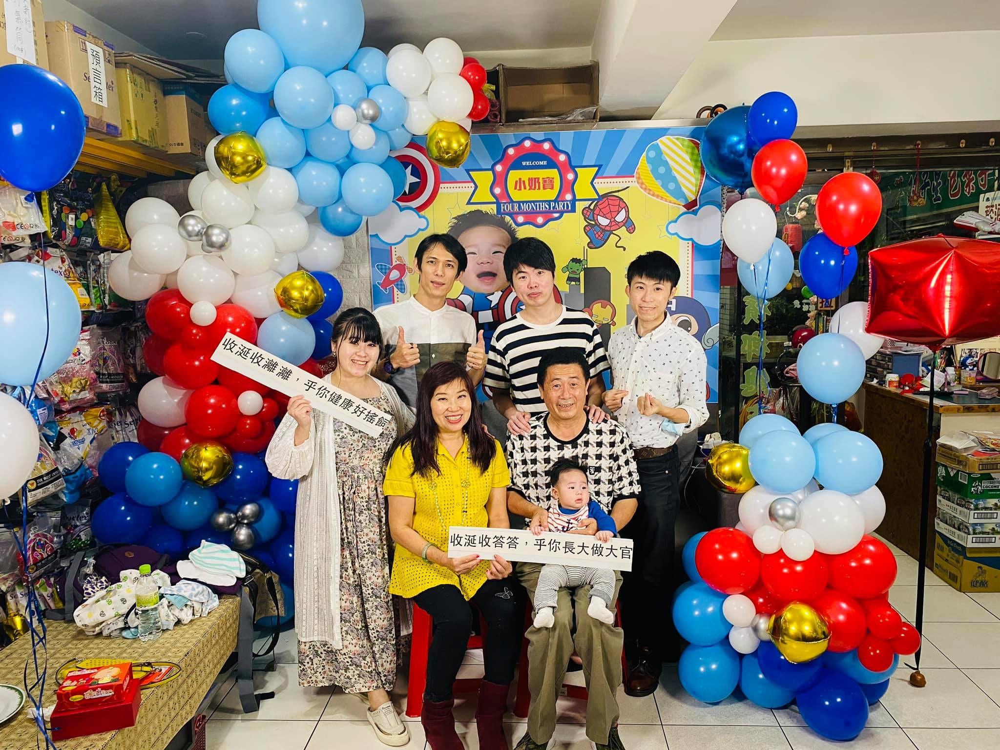 全家拿著收涎吉祥話字牌在美國隊長背板前合照