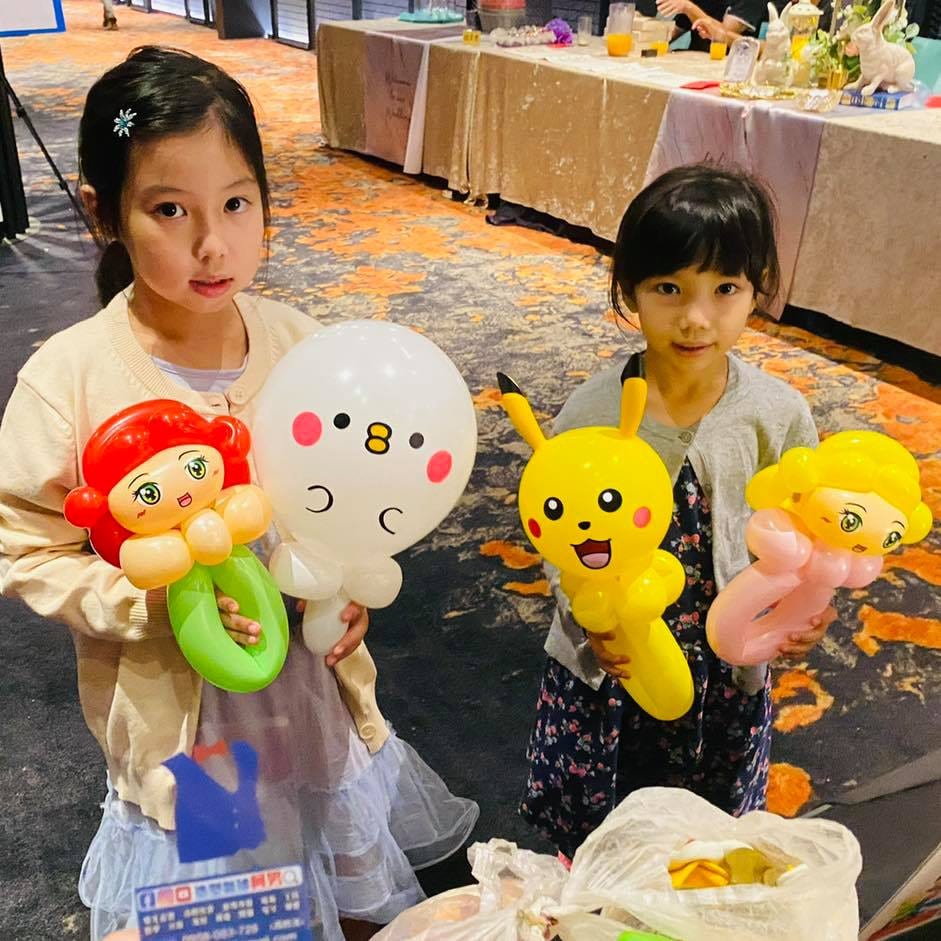 兩個女孩拿著小美人魚、皮卡丘與金髮公主氣球
