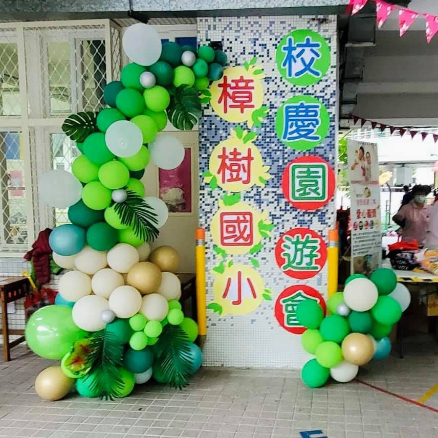 樟樹國小校慶園遊會看板旁的綠色氣球串與熱帶葉