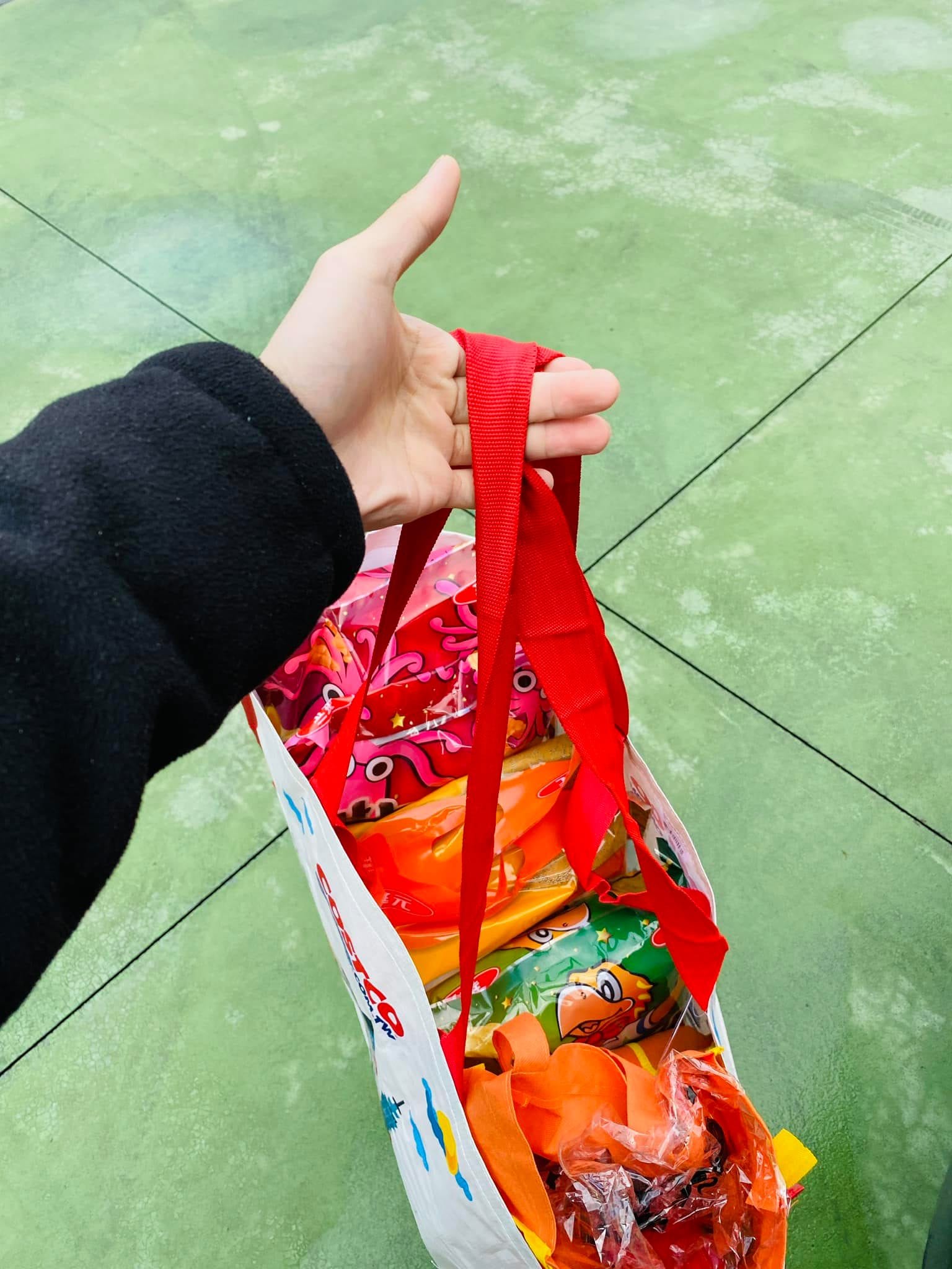 手提裝滿餅乾零食的聖誕小禮物袋