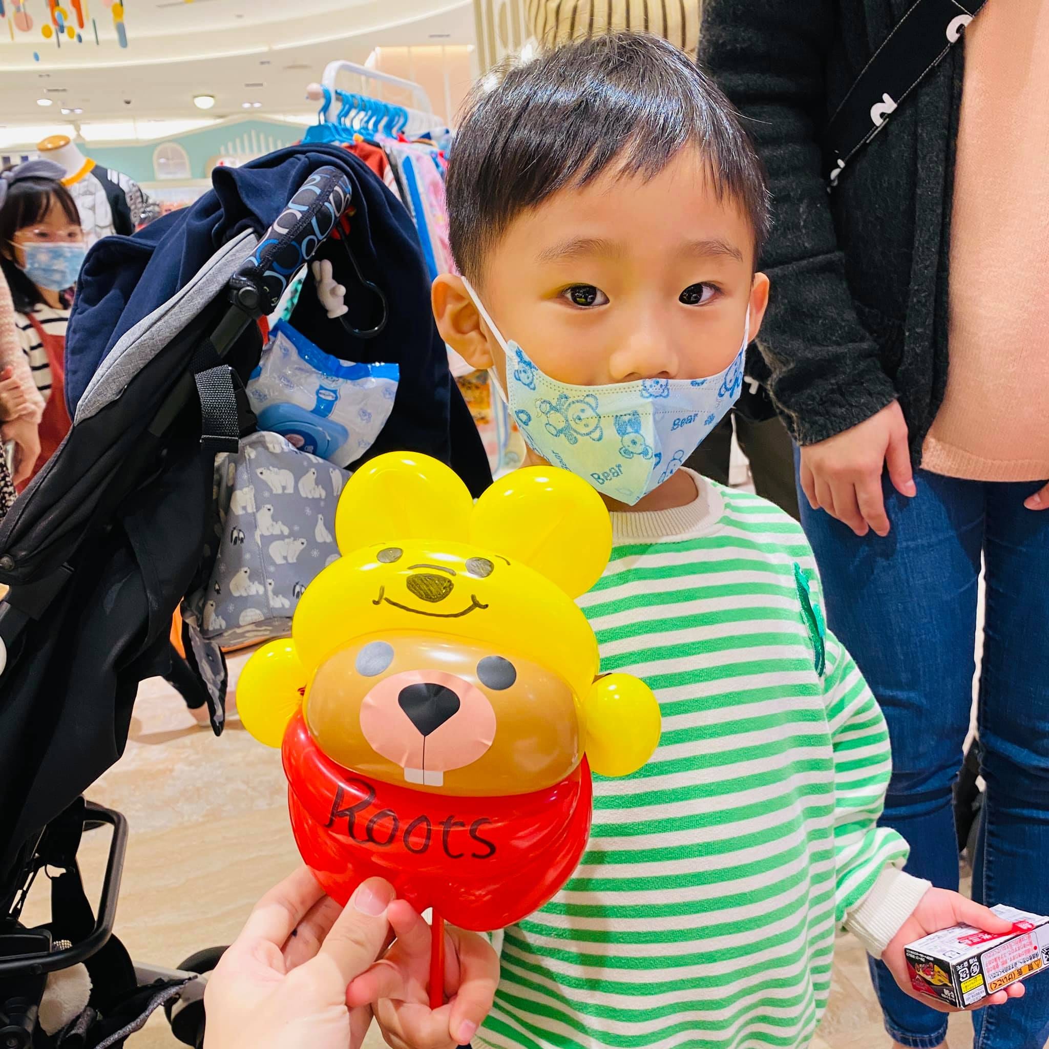 綠條紋上衣男孩拿著小熊維尼版海狸氣球