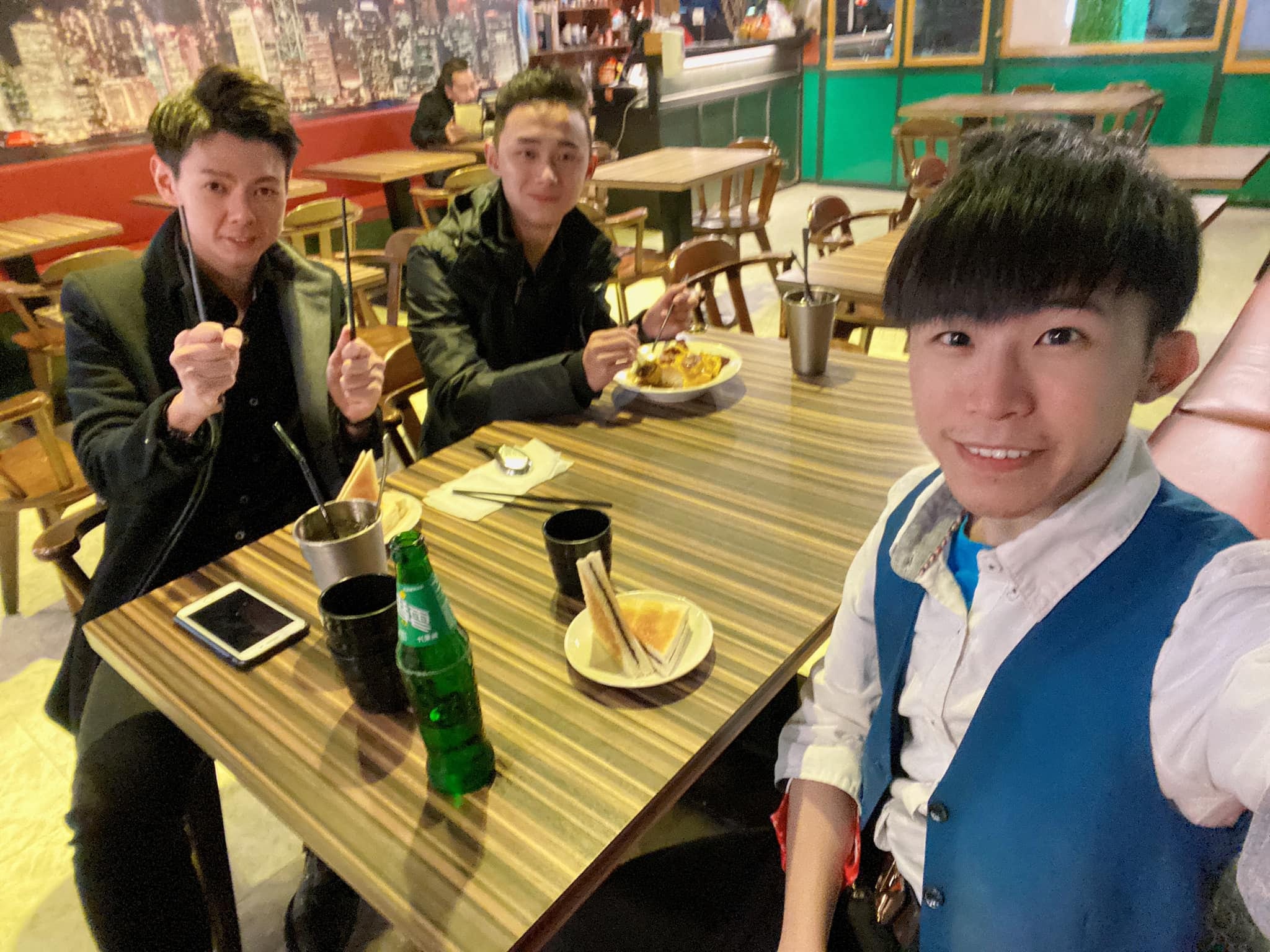 柯男與兩位朋友在餐廳餐桌旁自拍合照
