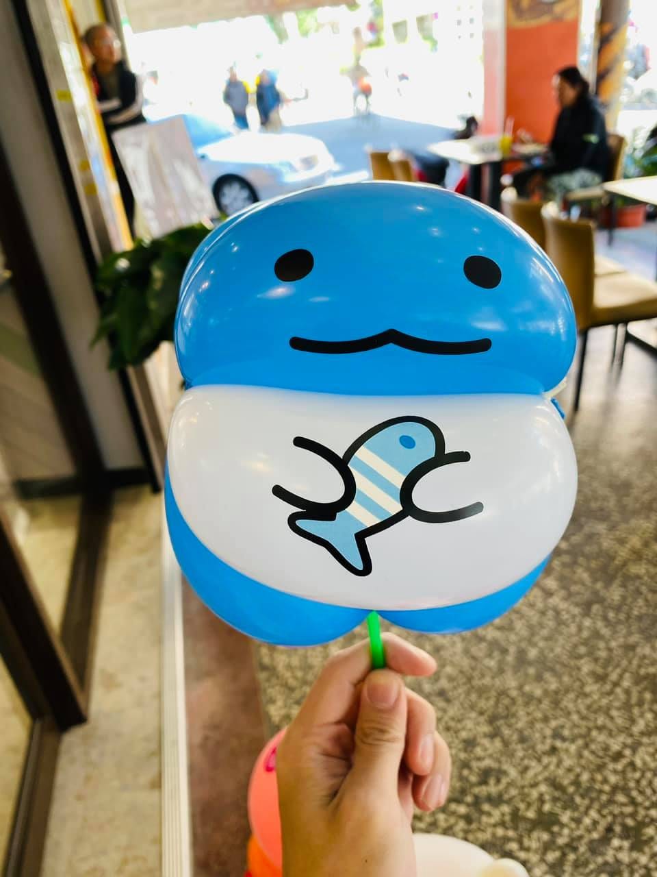 藍色圓頭、白肚子畫著小魚的角色造型氣球