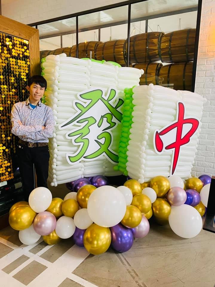 白色長條氣球疊成的巨型麻將牌發與紅中，底座金紫白圓球