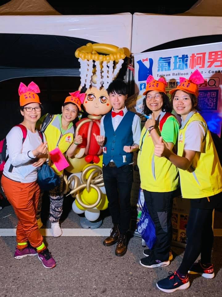 戴橘色兔耳帽的進香民眾與柯男、氣球媽祖合照比讚