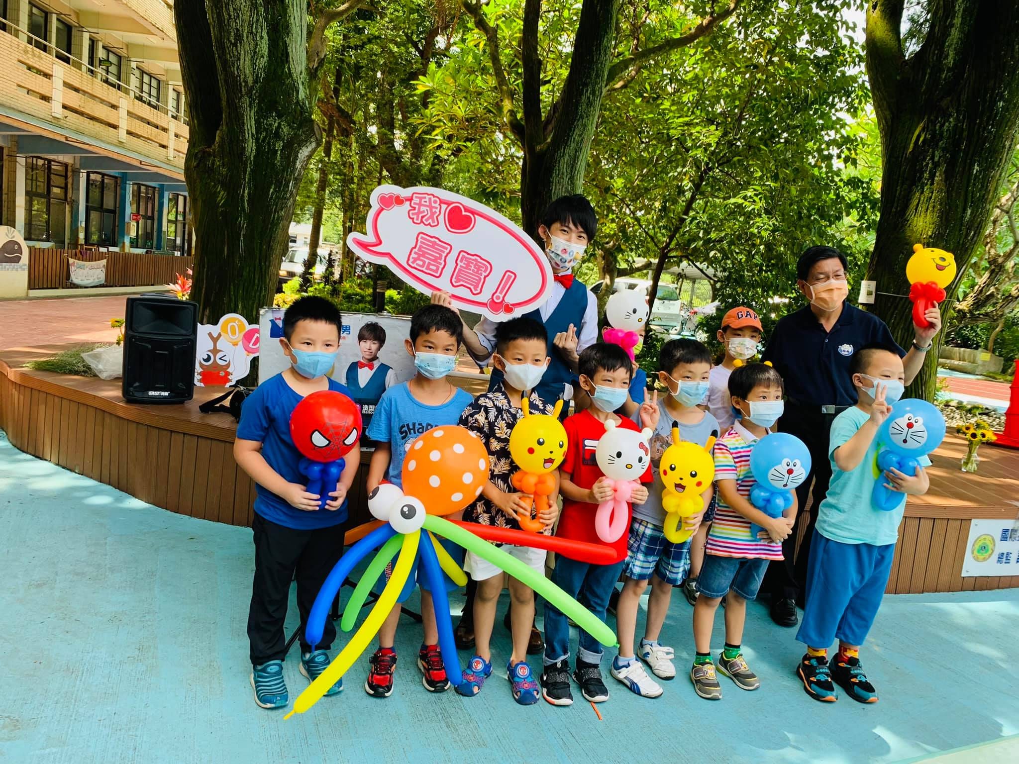 男孩們拿著蜘蛛人、皮卡丘、哆啦A夢氣球，柯男舉著「我愛嘉寶」牌
