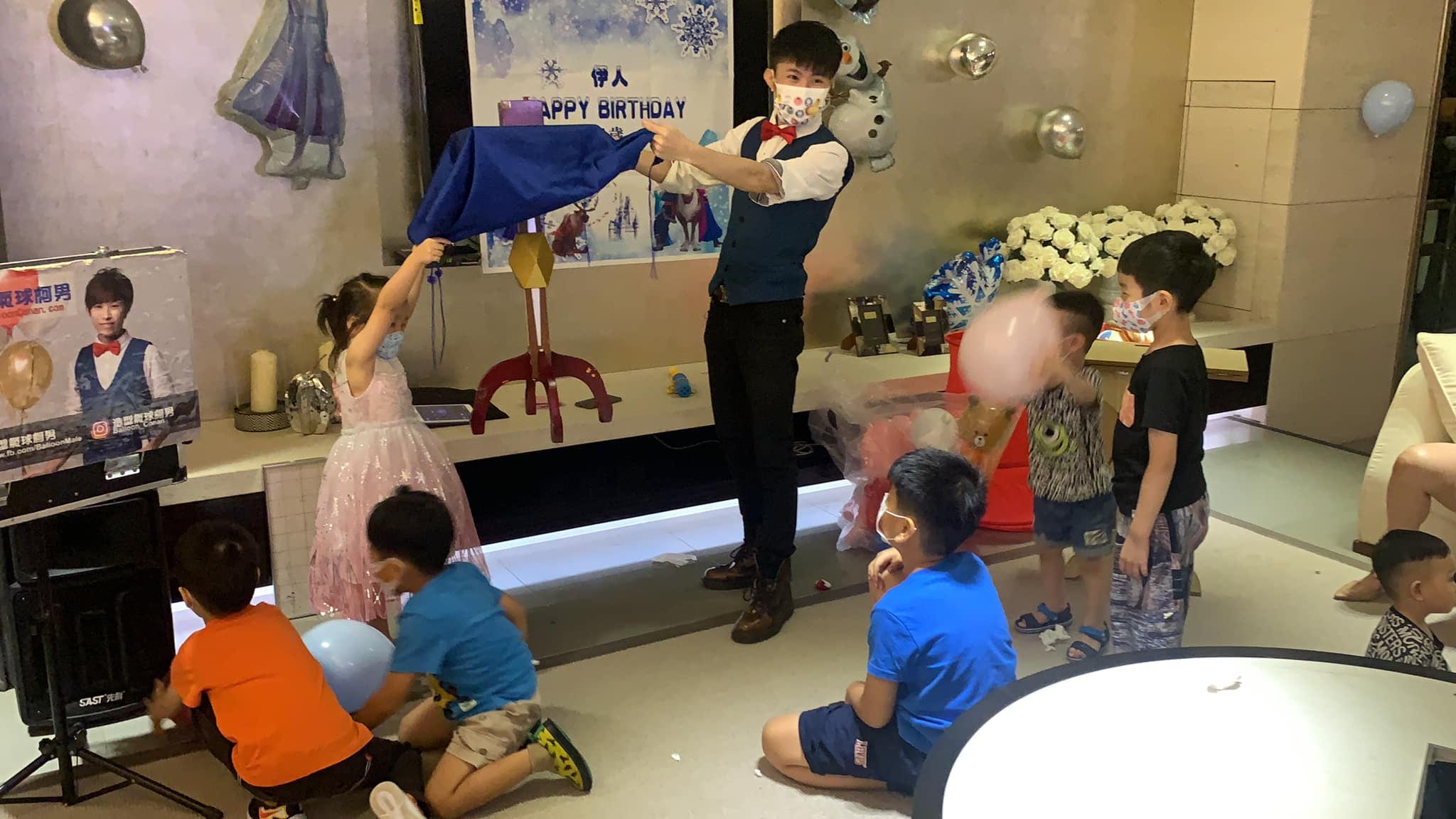 客廳裡的魔術表演,柯男拿藍色魔術布,穿粉紅紗裙的女孩上台