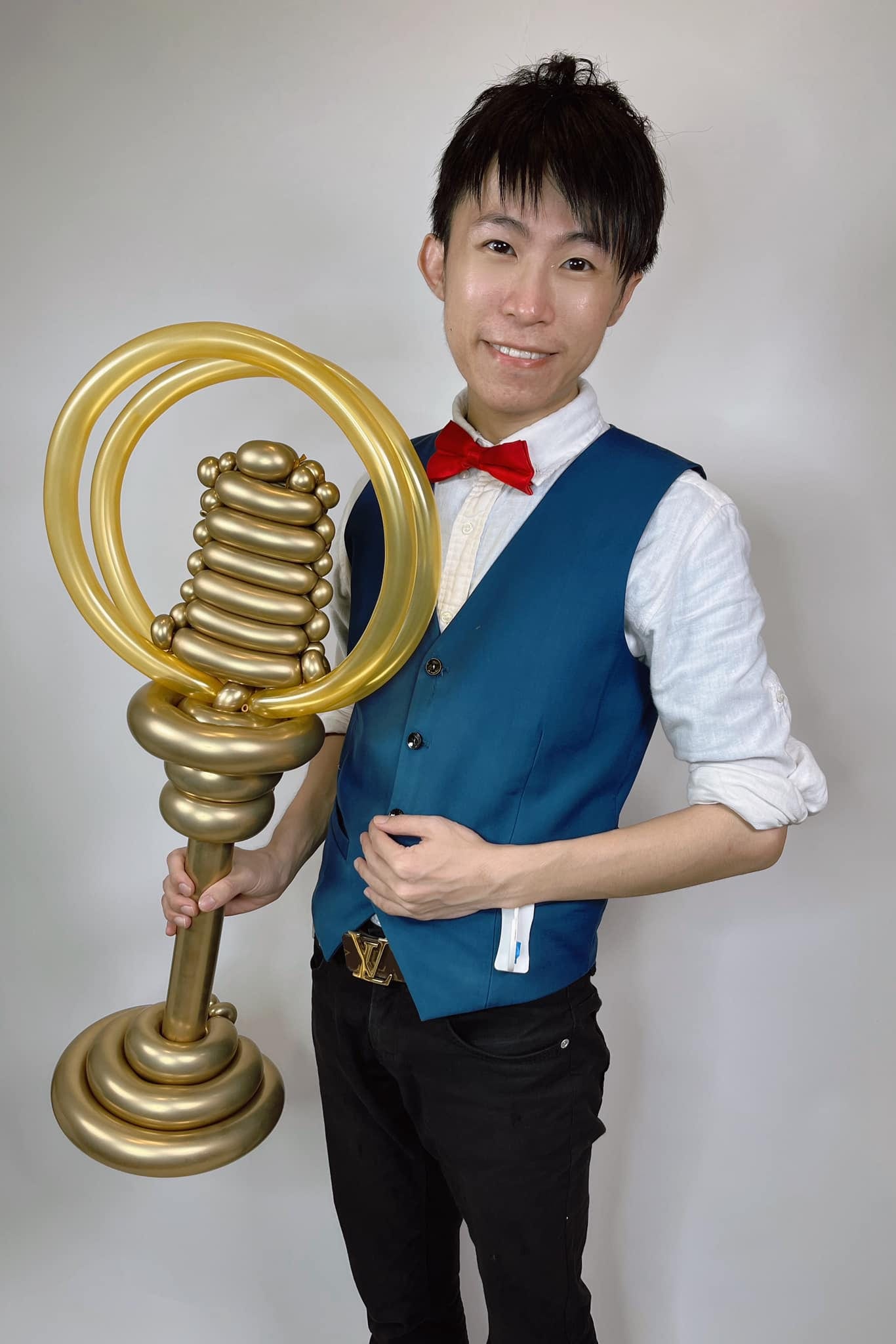 柯男手拿金色麥克風造型的金鐘獎盃氣球