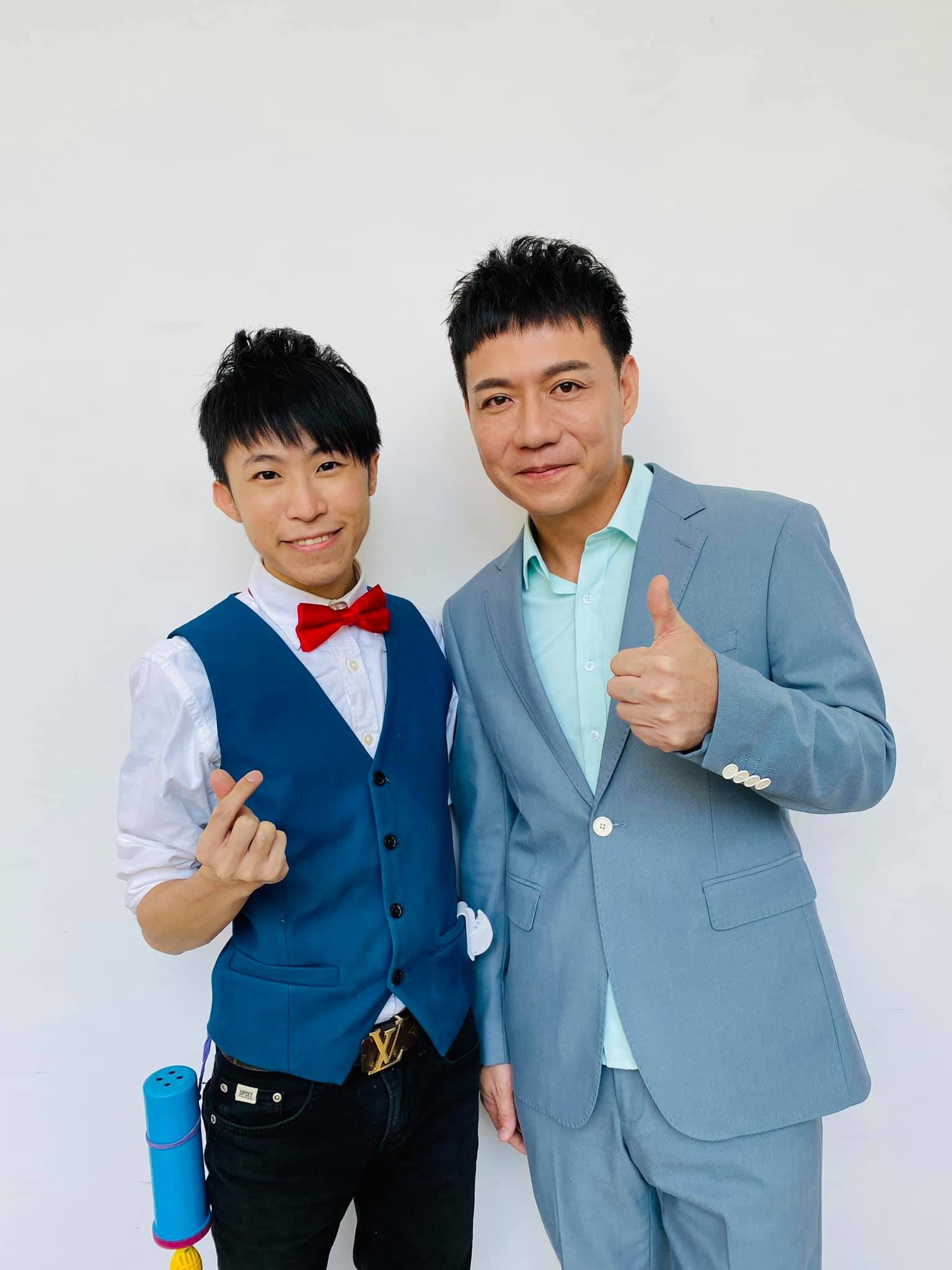 柯男與穿淺藍西裝的來賓在後台白牆前合照