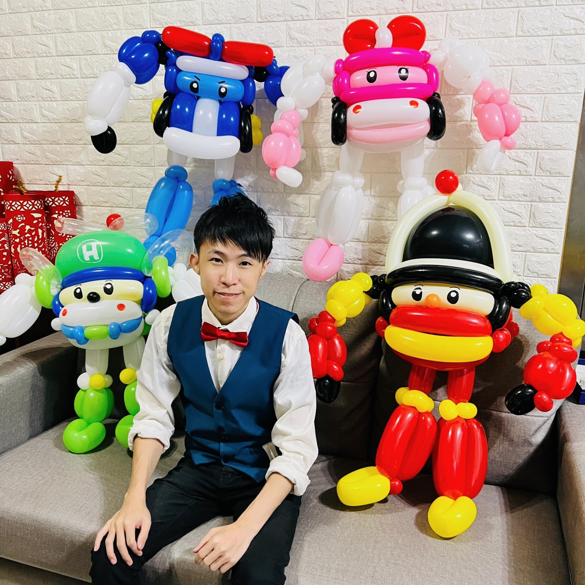 柯男坐在沙發上，身後是四隻救援小英雄氣球人偶