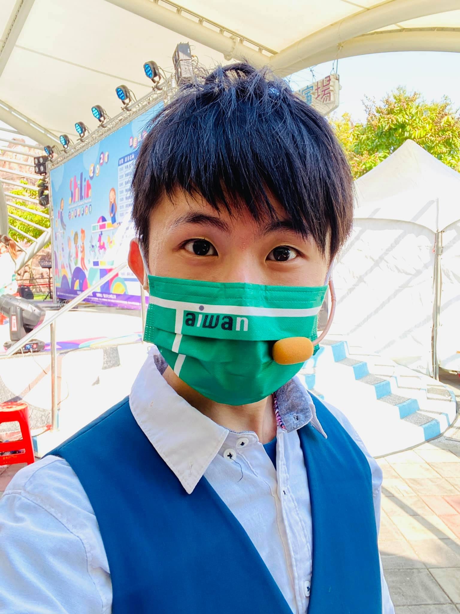 柯男戴著耳麥與口罩,在戶外舞台旁自拍