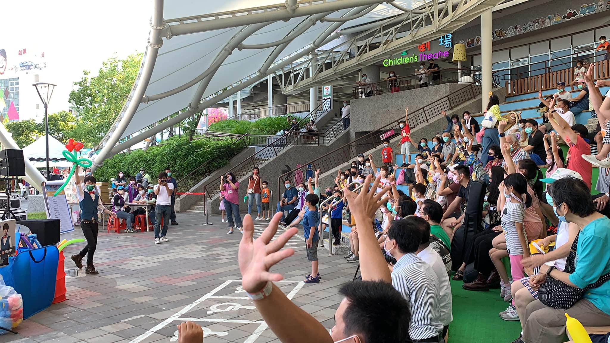 台北士林戶外廣場,柯男舉著愛心造型氣球表演,看台觀眾舉手