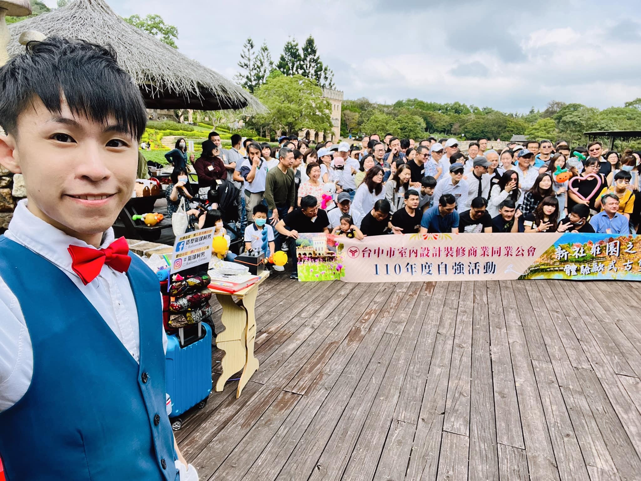 台中市室內設計裝修公會自強活動布條前，柯男與大合照的會員家屬