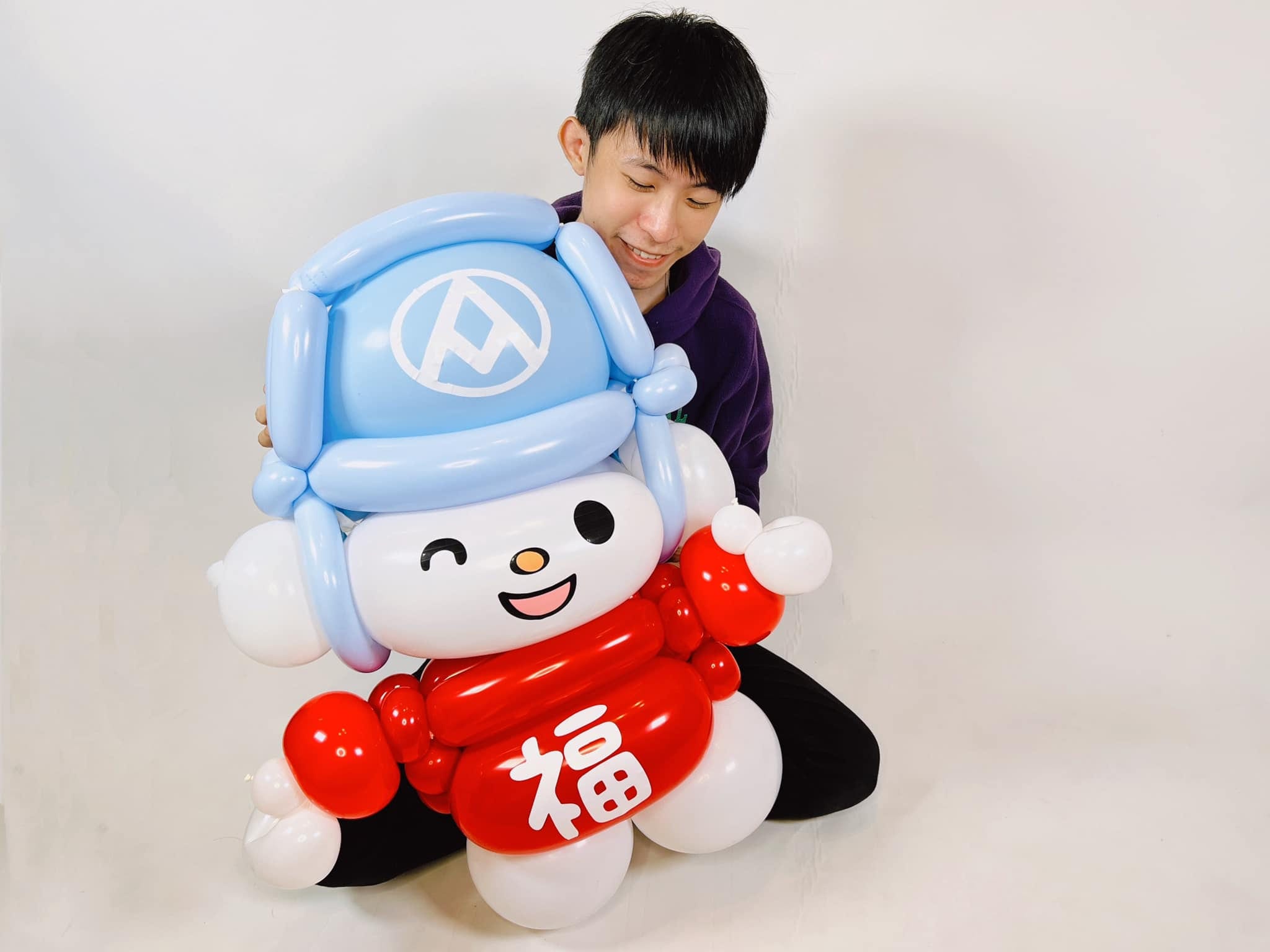 柯男坐在地上，抱著大型福利熊氣球人偶