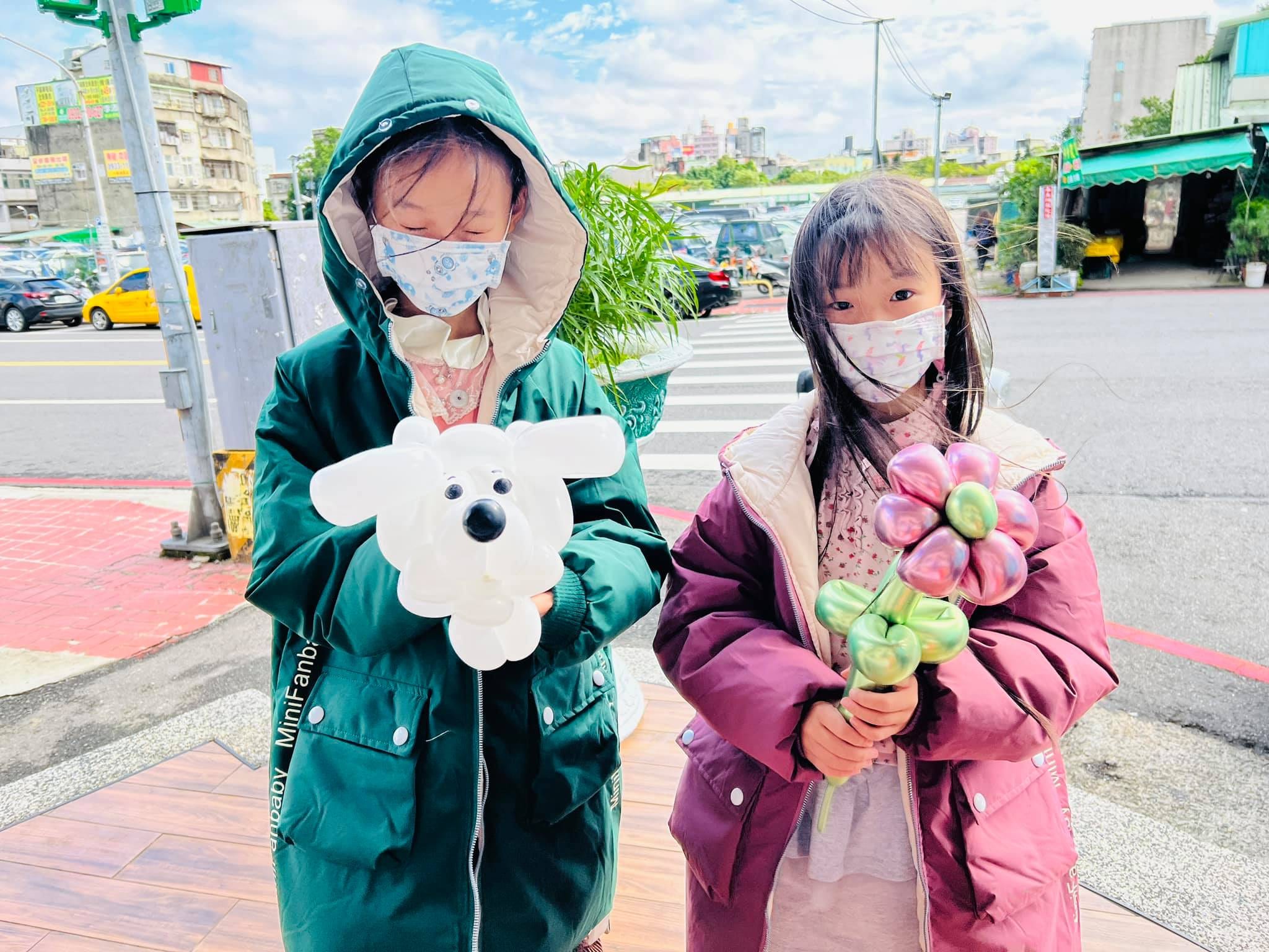 兩個女孩拿著白色小狗與金屬色花朵造型氣球