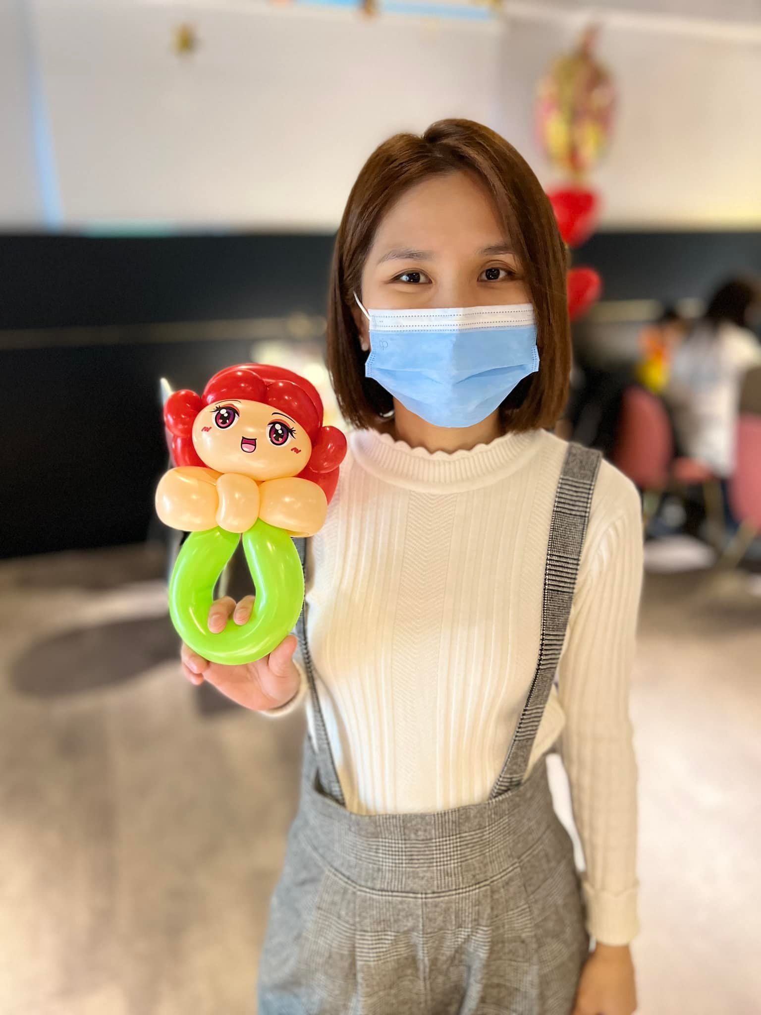 賓客拿著紅髮公主造型氣球，下方是綠色手環