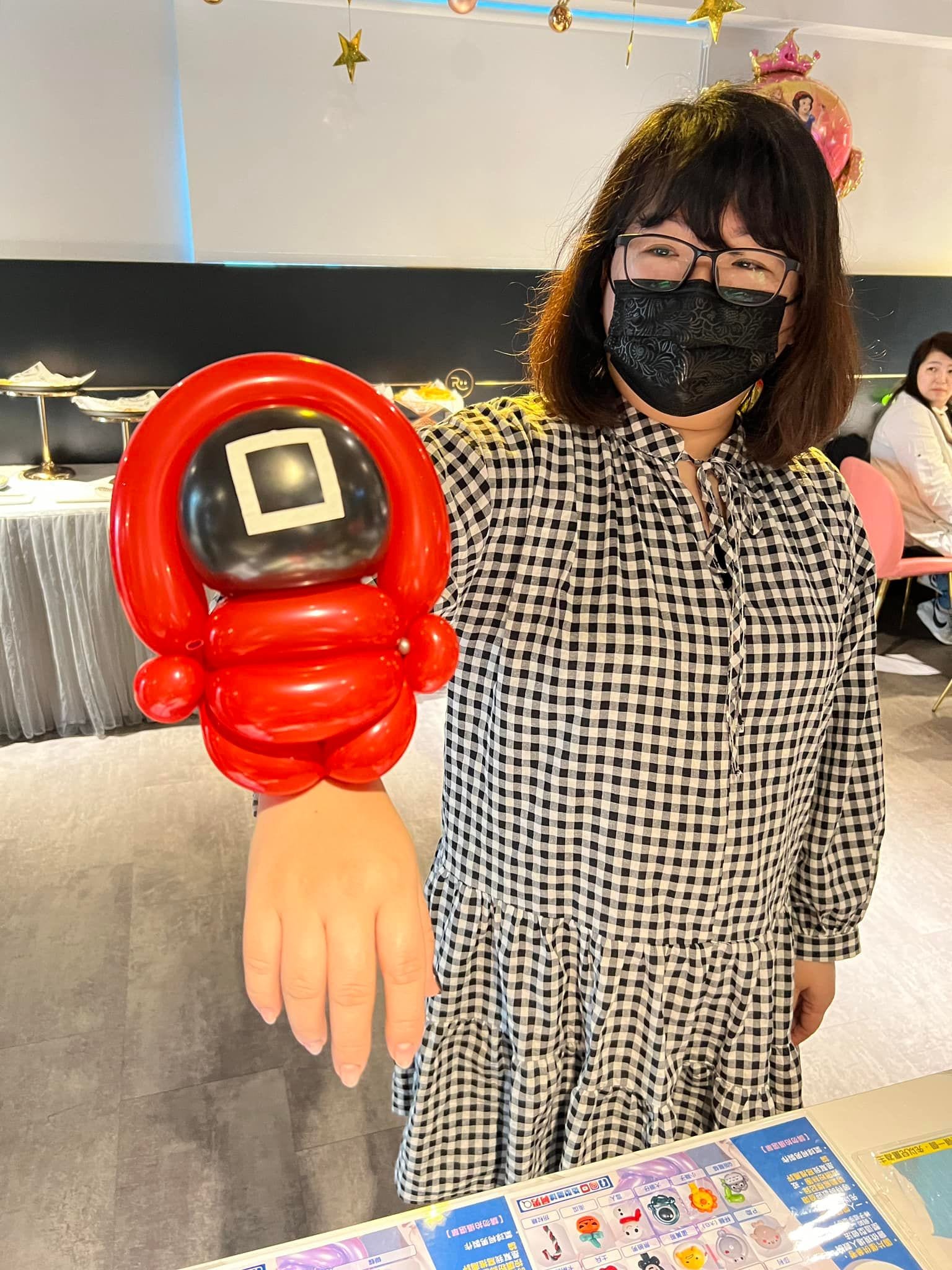 賓客手上套著方塊面具的魷魚遊戲面具人氣球