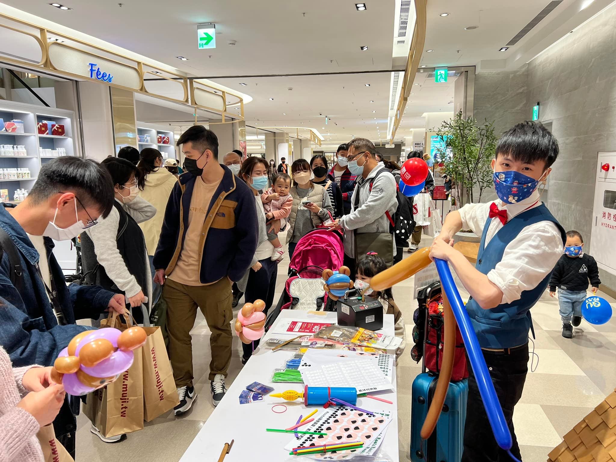 竹北遠東商場走道上,柯男在 Roots 櫃位旁現場折氣球
