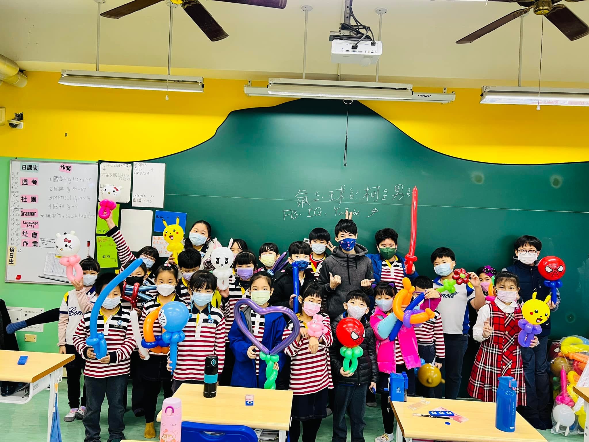 學生們拿著蜘蛛人、小熊維尼與愛心氣球站在黑板前