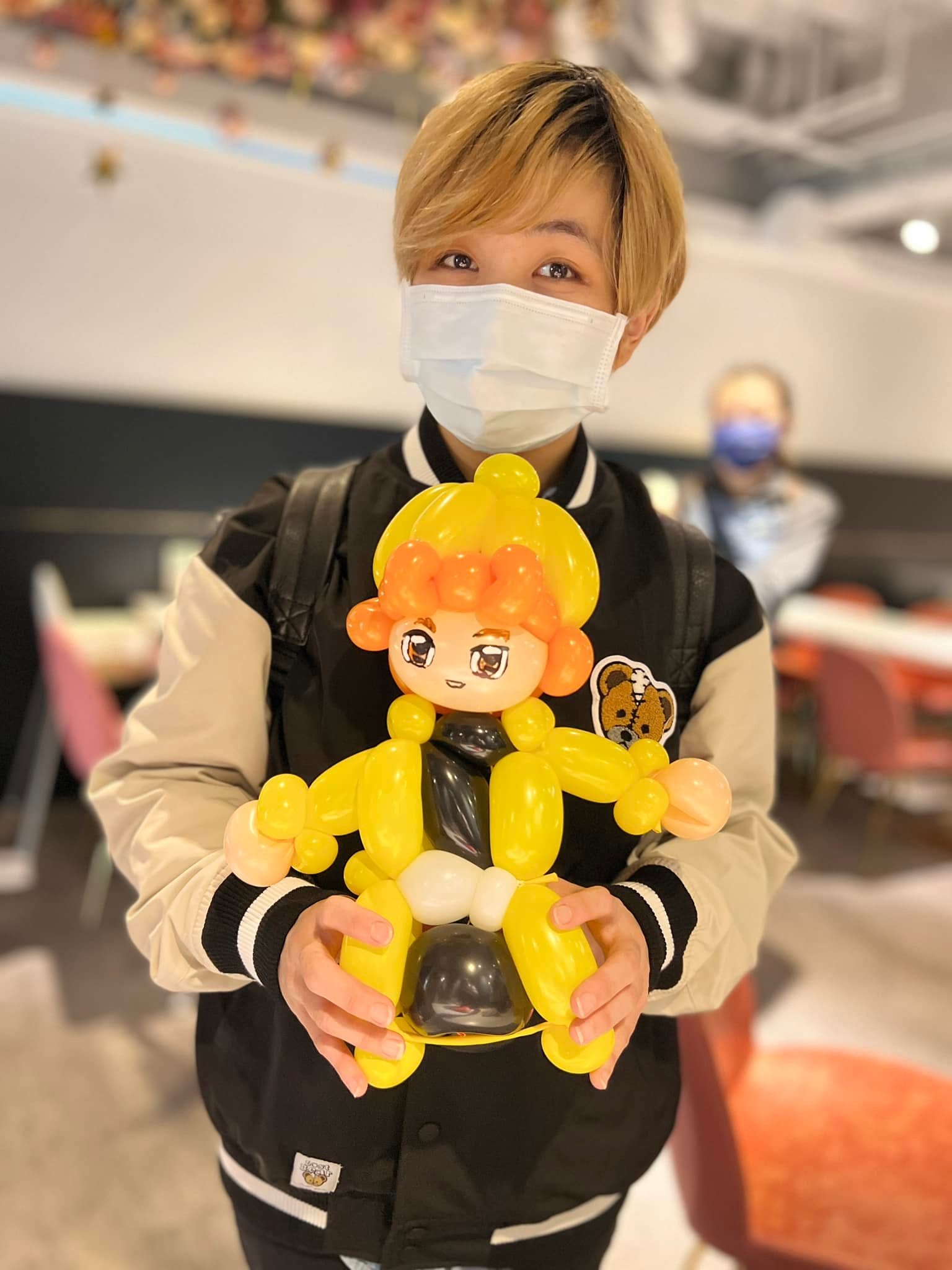 賓客捧著鬼滅之刃善逸造型氣球，黃髮橘色髮尾與黃色羽織