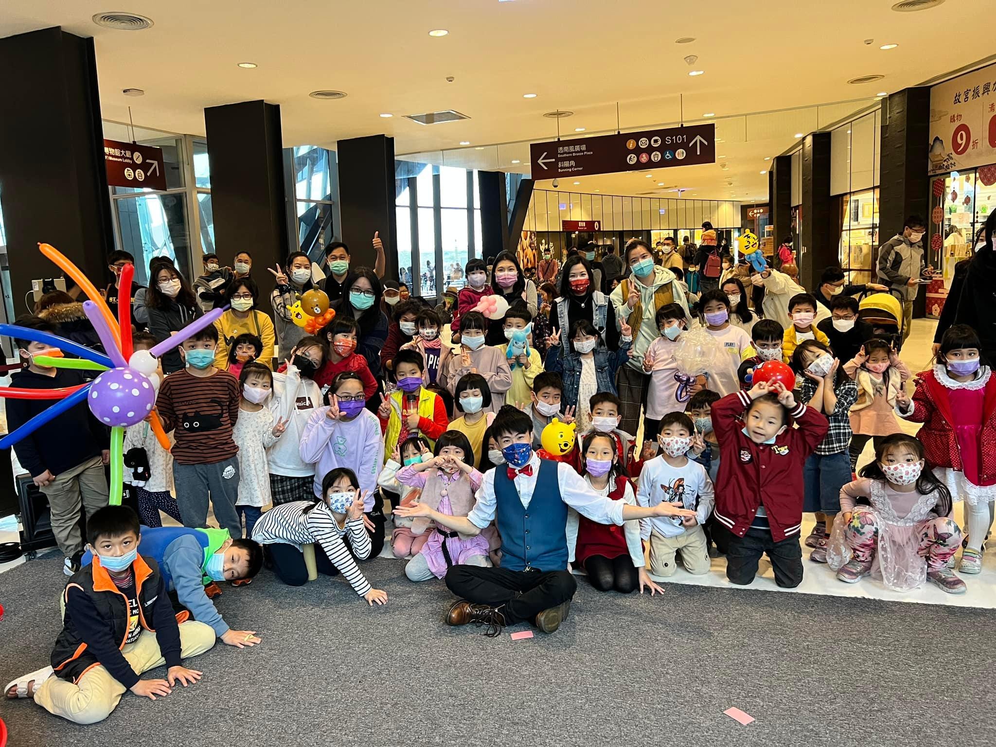 演出後小朋友拿著造型氣球，在故宮南院大廳與柯男合照