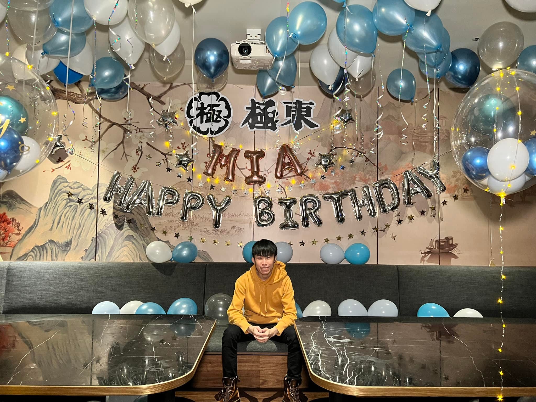 柯男坐在包廂沙發上，後方是客製字樣板與銀色生日字母
