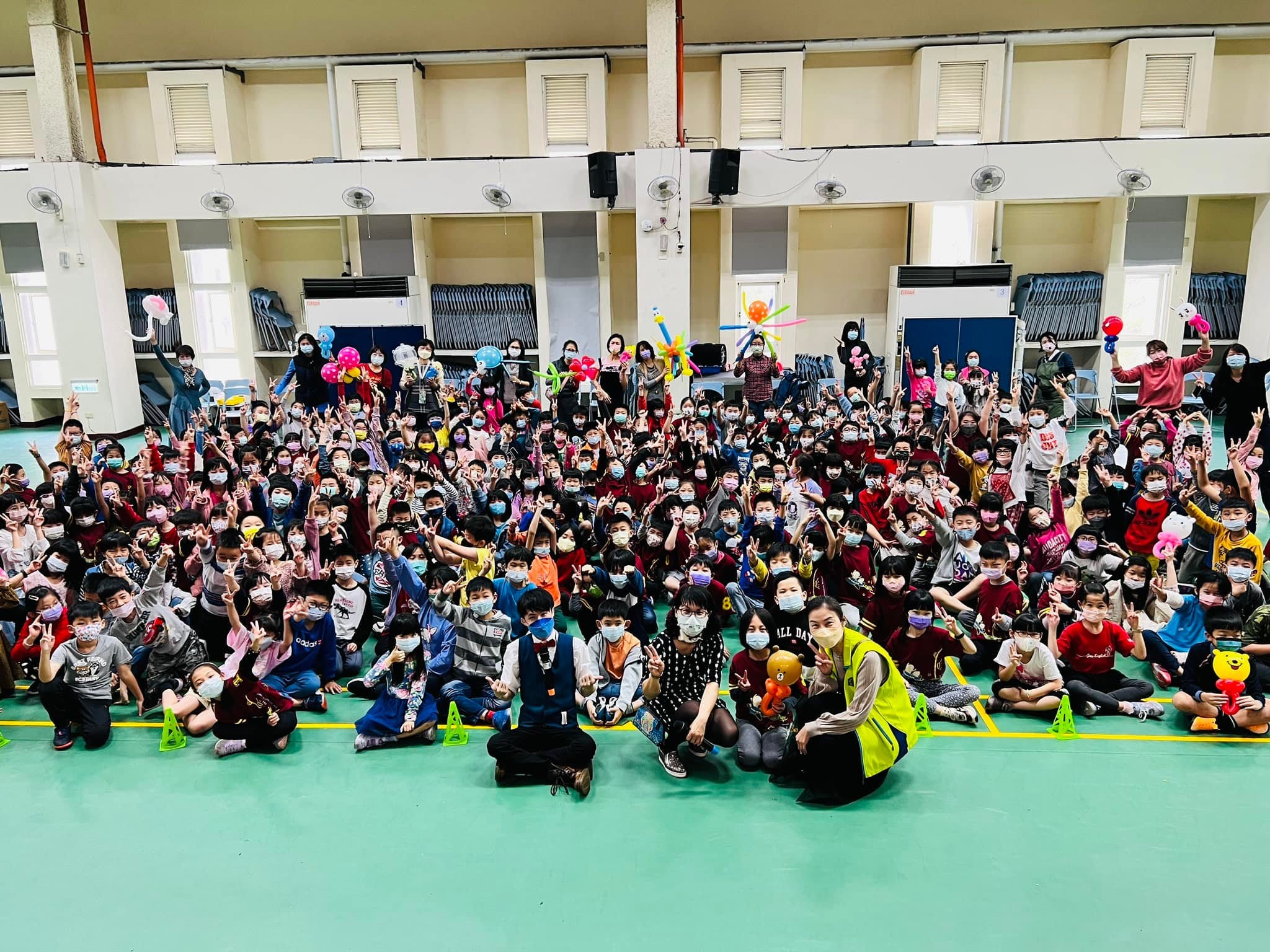 台中國安國小學生在禮堂拿著造型氣球,與柯男大合照