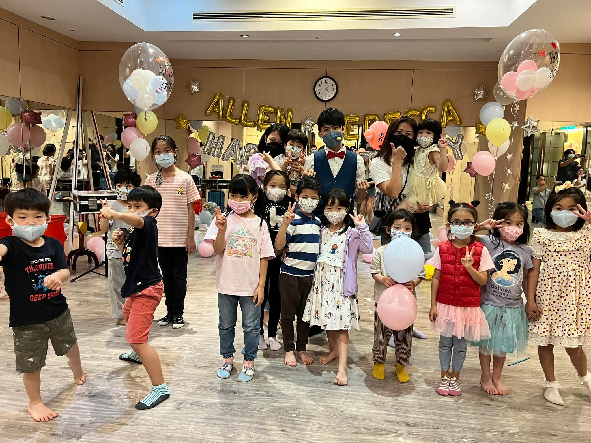 小朋友們在粉彩氣球生日背景前比 YA 合照