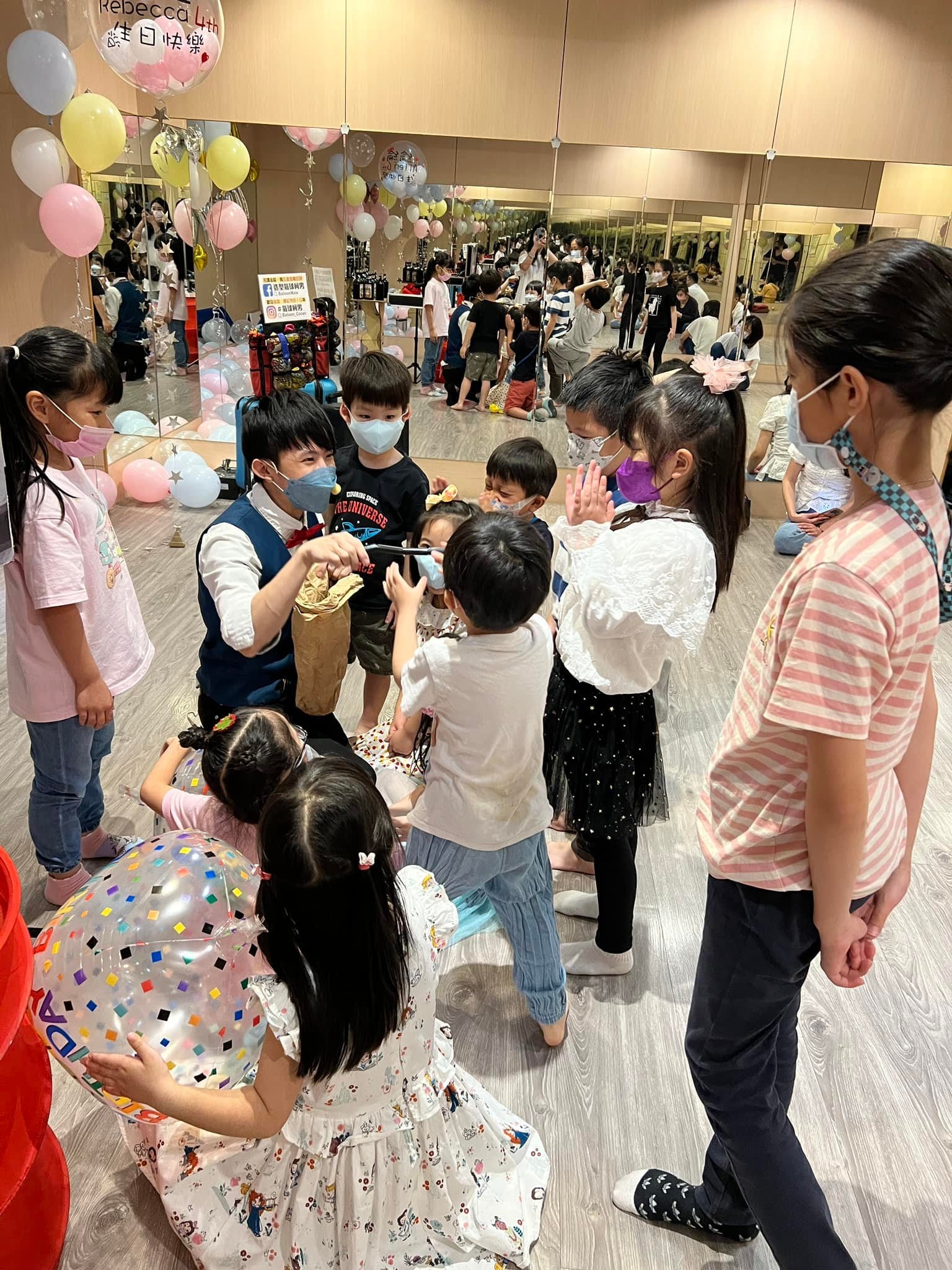 柯男手拿魔術道具，小朋友圍在身邊看生日派對魔術