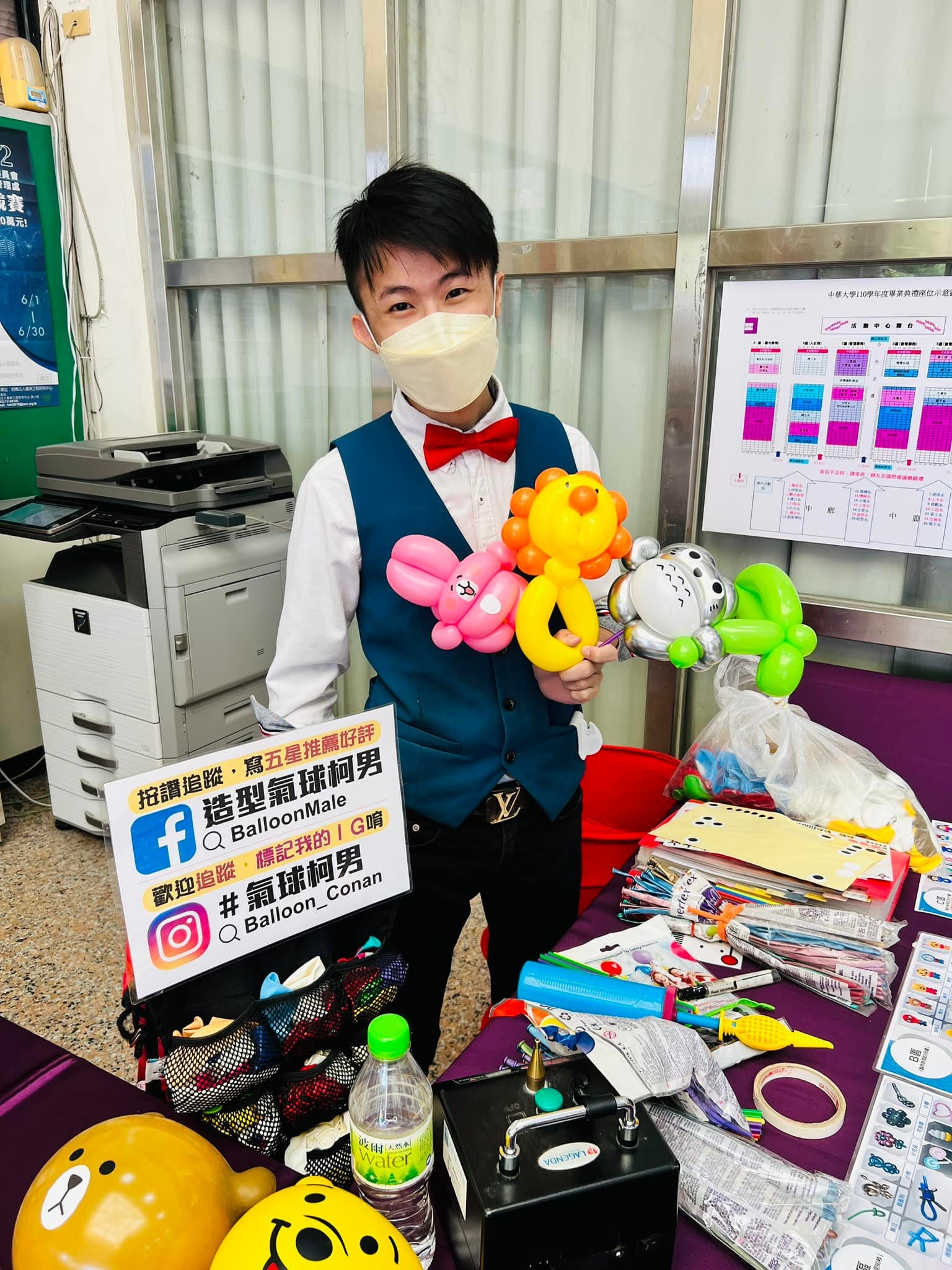 柯男站在折氣球攤位後,手上拿著一束剛折好的造型氣球