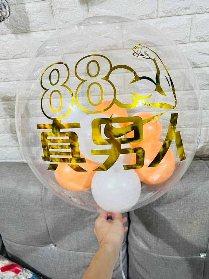 透明泡泡氣球上貼著金色 88 真男人字樣，裡面是橘色小氣球