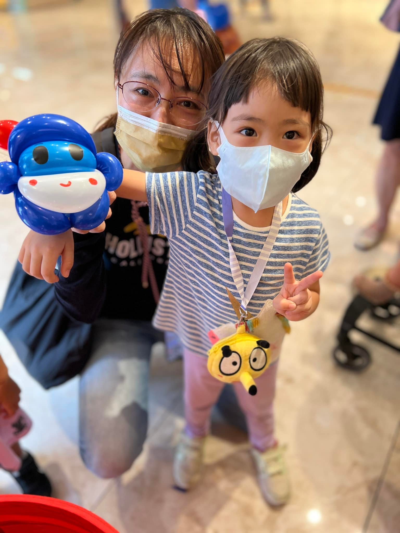 媽媽和比 YA 的女兒,手上拿著藍色圓頭機器人氣球