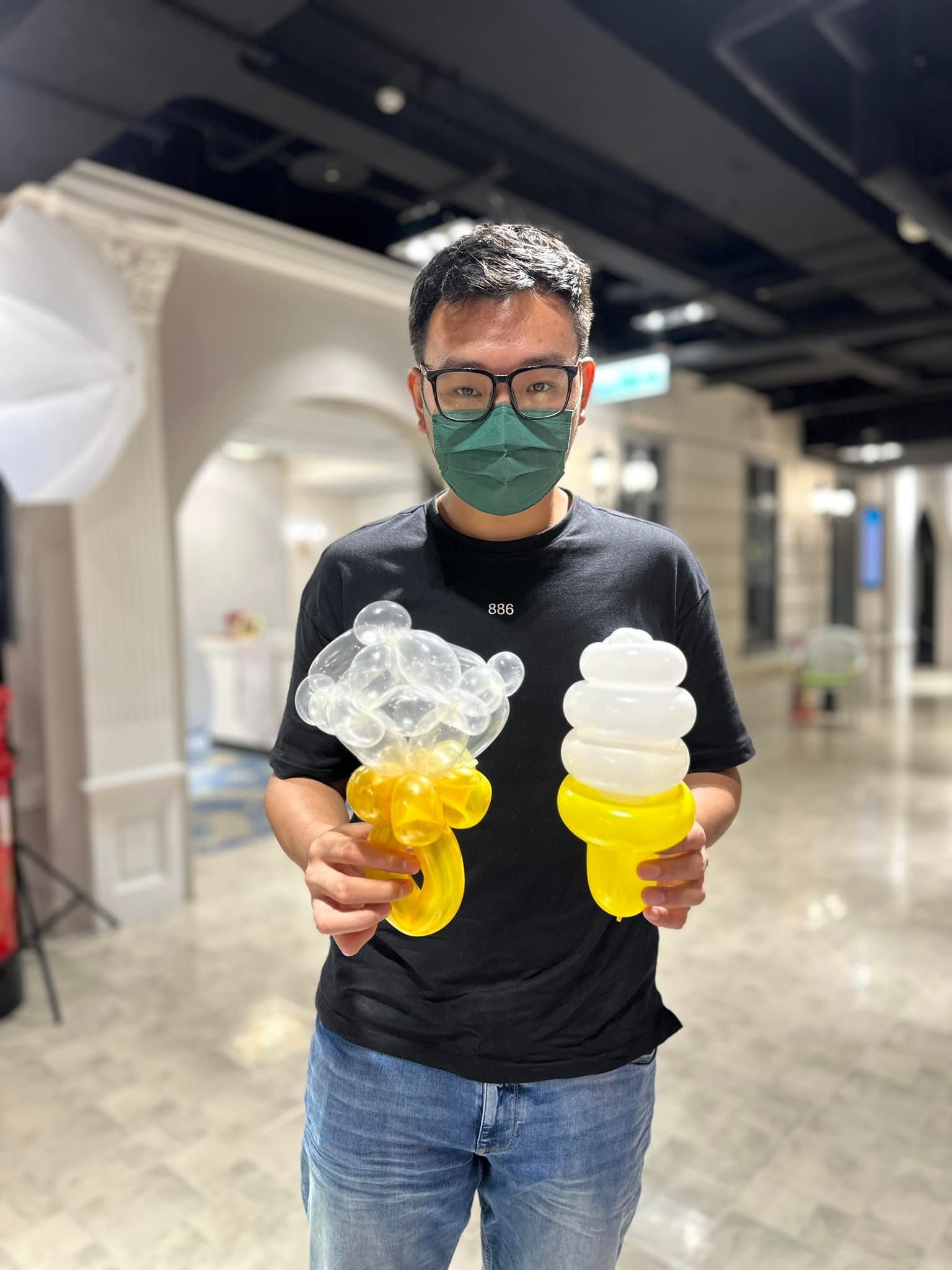 男賓客拿著透明泡泡與黃色緞帶造型的花束氣球,以及黃白冰淇淋氣球