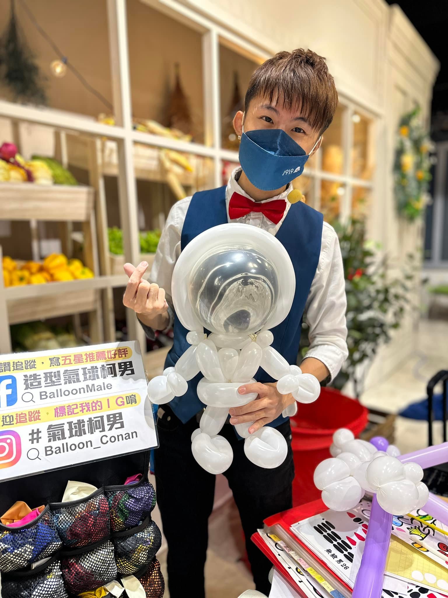 柯男拿著全白、透明頭盔的太空人造型氣球