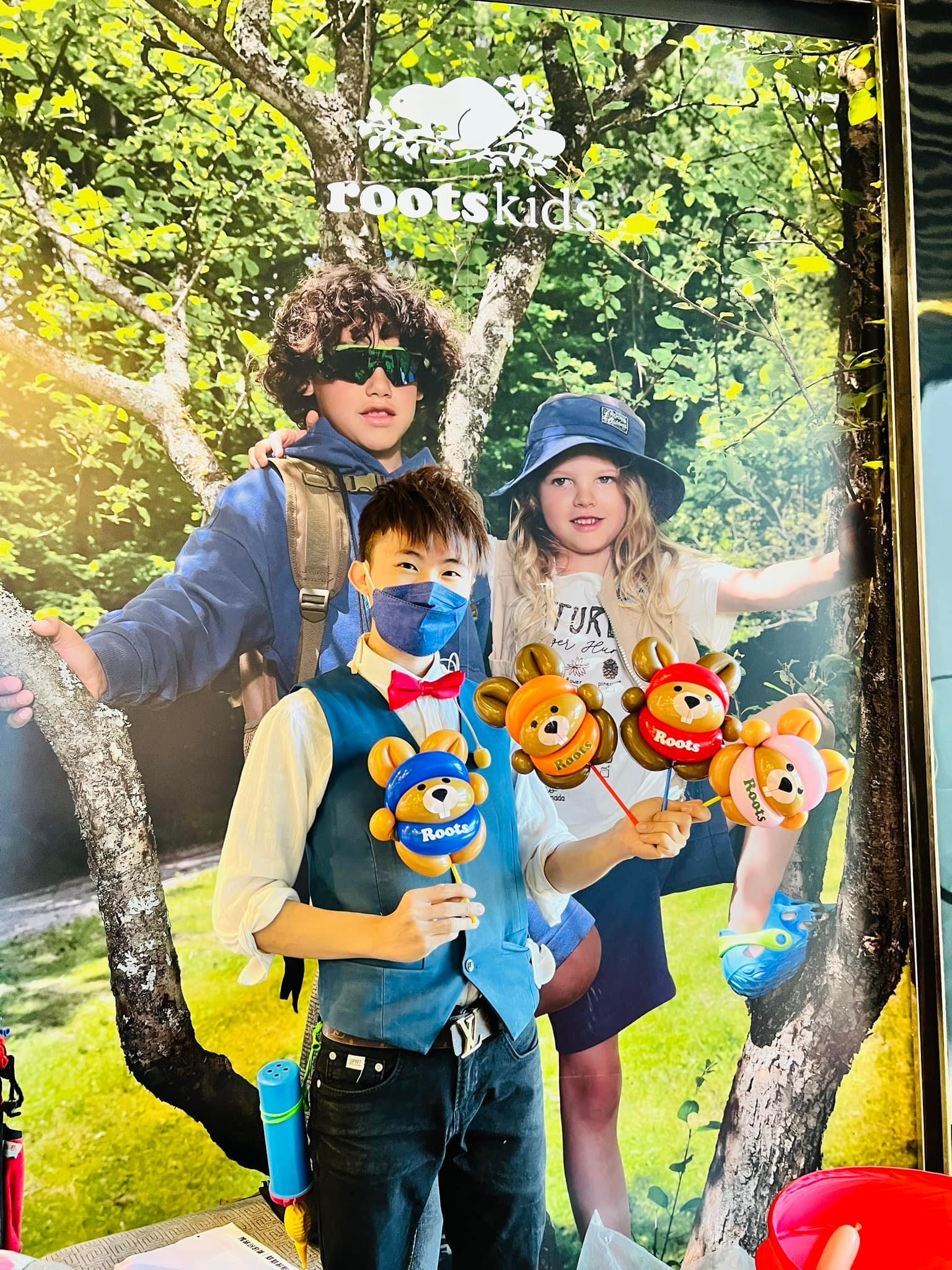 汐止遠雄廣場 RootsKids 海報前，柯男拿著四隻海狸寶寶氣球