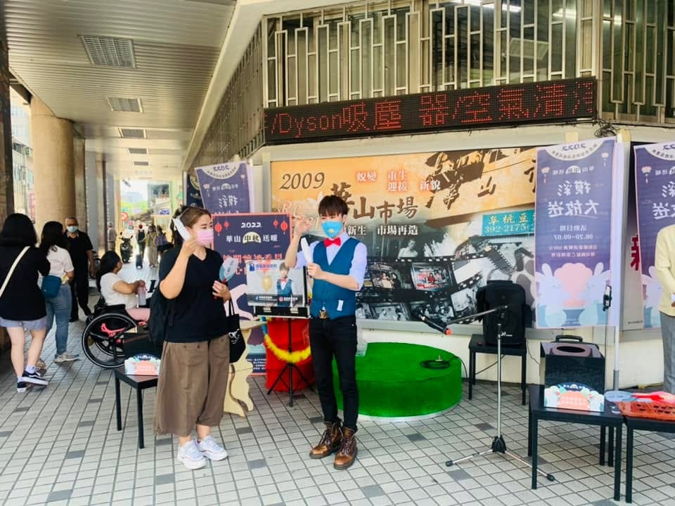 公益募款魔術秀現場,路過民眾停下腳步觀看,後方有輪椅上的觀眾
