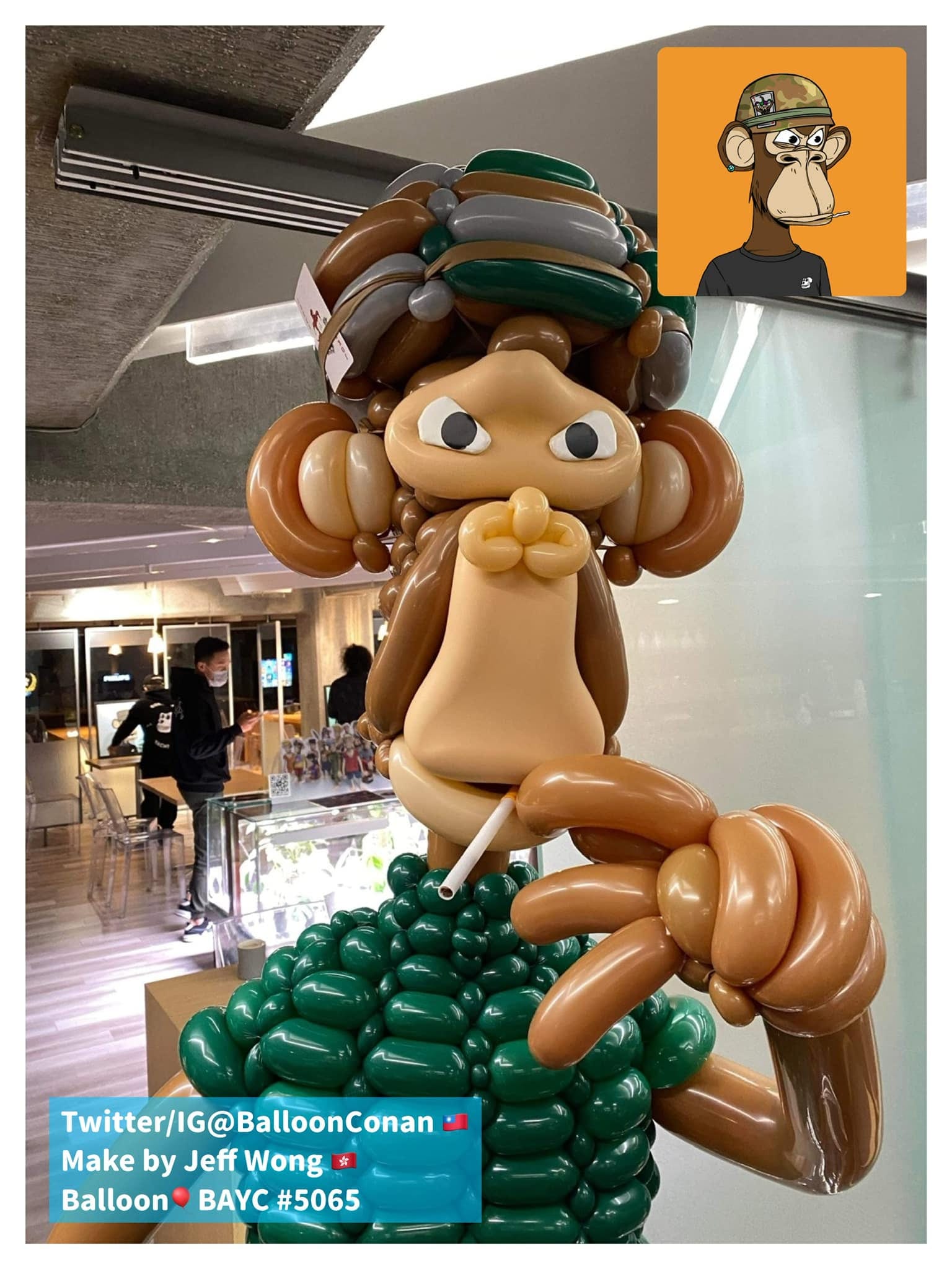 迷彩軍裝無聊猿氣球的臉部特寫,嘴裡叼著白色吸管、手扶下巴