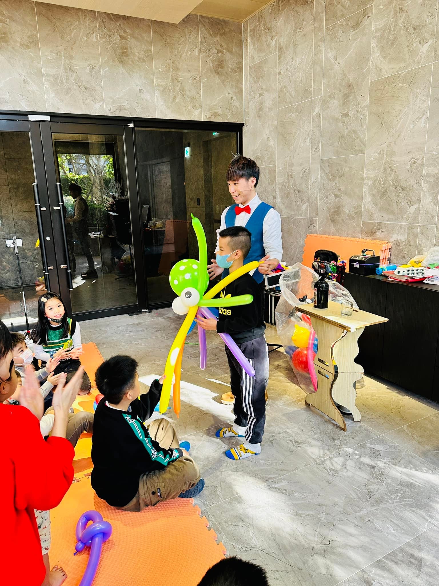 上台的男孩舉著綠色三眼怪造型氣球，柯男站在一旁