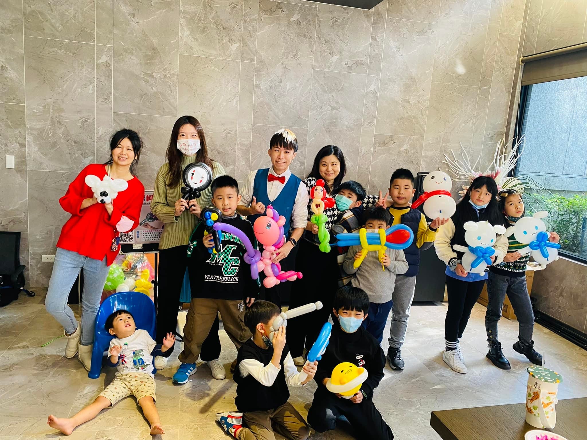 聖誕派對上，孩子們拿著造型氣球和柯男在客廳大合照