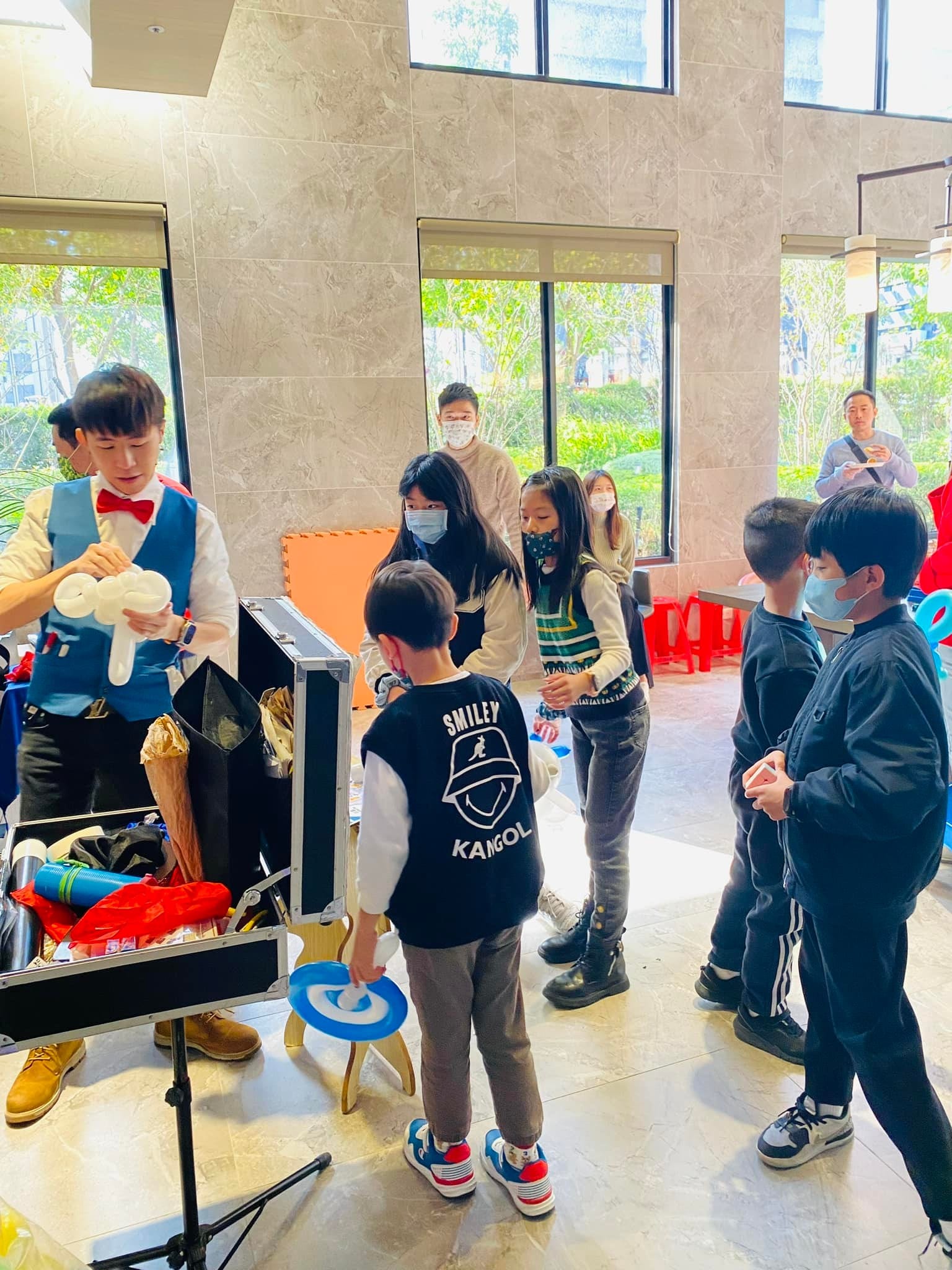 孩子們排隊走向柯男的道具箱，準備參與魔術互動