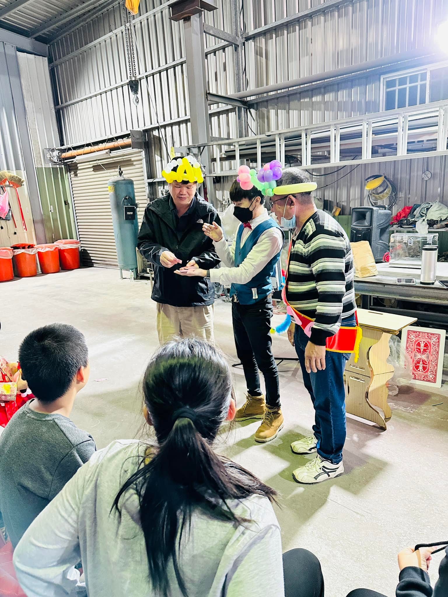 兩位戴著氣球帽的大人上台，和柯男一起完成魔術
